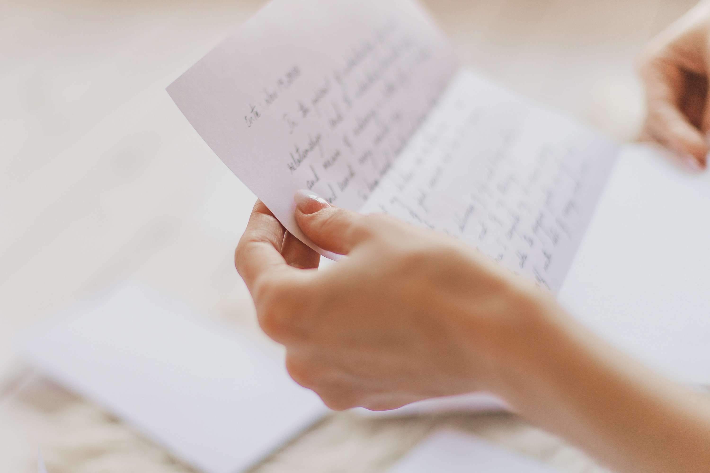 Hands of young woman holding handwritten letter. | Source: Shutterstock