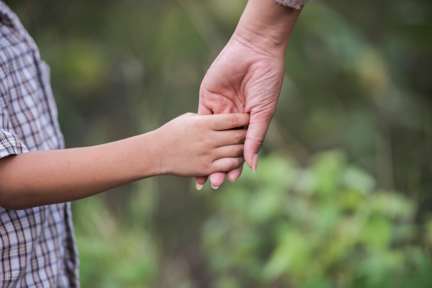 A woman holding a boy's hand | Source: Freepik