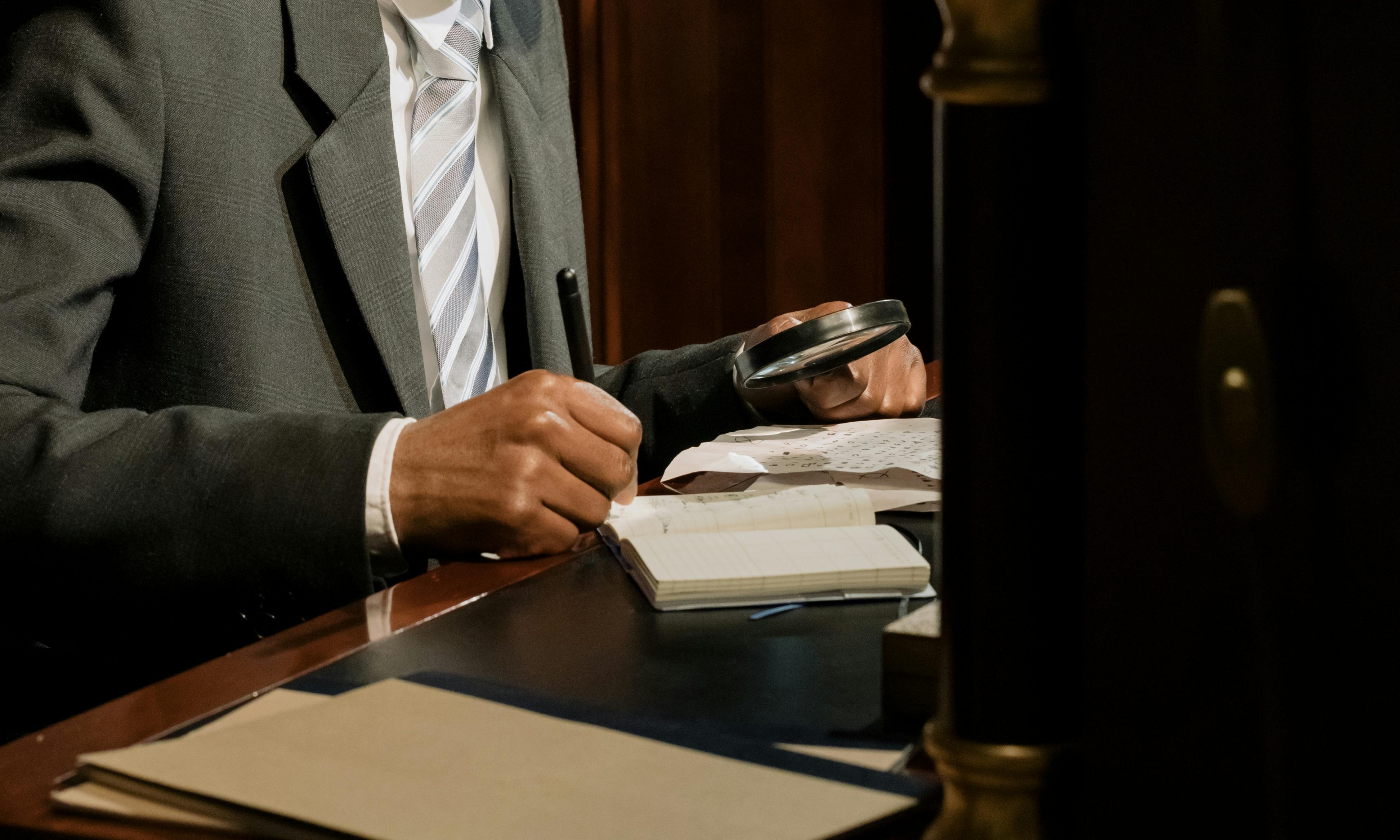 A man inspecting documents with a magnifying glass | Source: Pexels