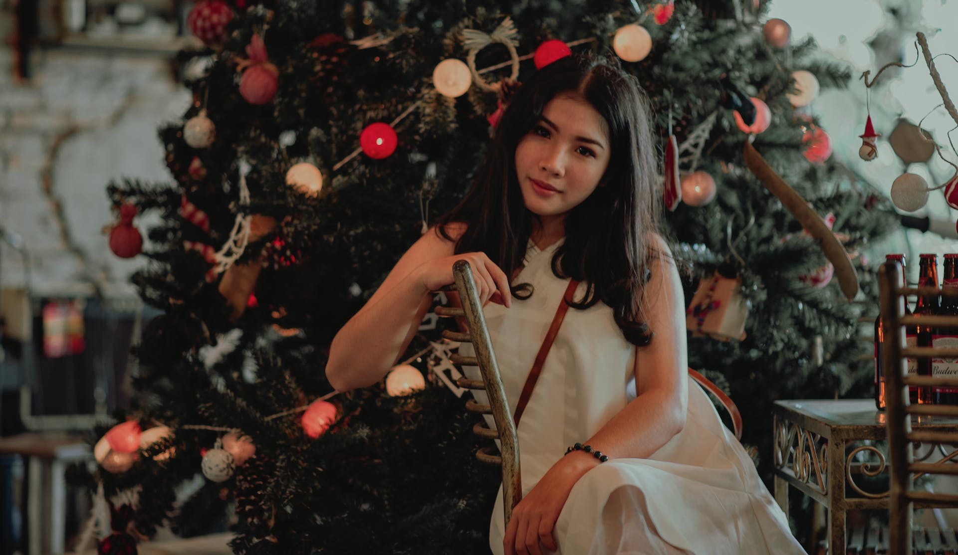 A woman sitting in front of a Christmas tree. | Source: Pexels