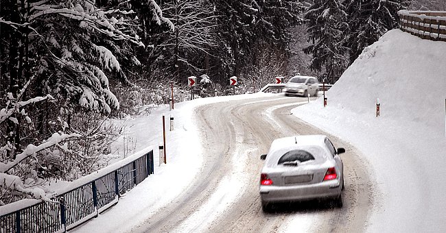 Cars traveling on a snowy road. | Photo: Shutterstock