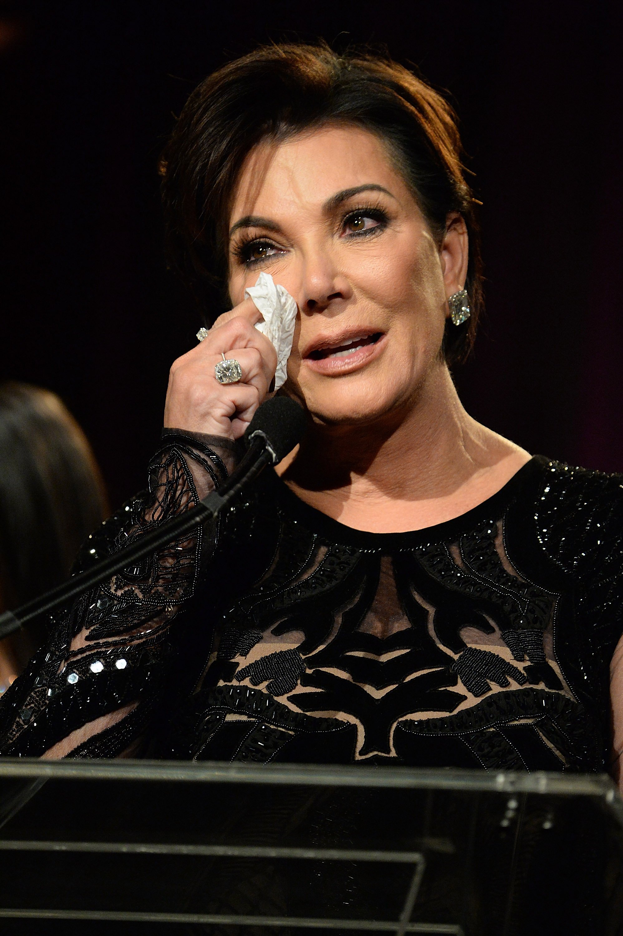 Kris Jenner wiping off tears as she speaks onstage during the 2016 Angel Ball. | Photo: Getty Images