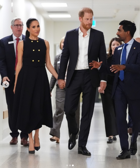 The Duke and Duchess of Sussex walked hand in hand through a hospital corridor, speaking with staff during their Melbourne visit, as seen in a post dated 14 April 2026. | Source: Instagram/hellomag