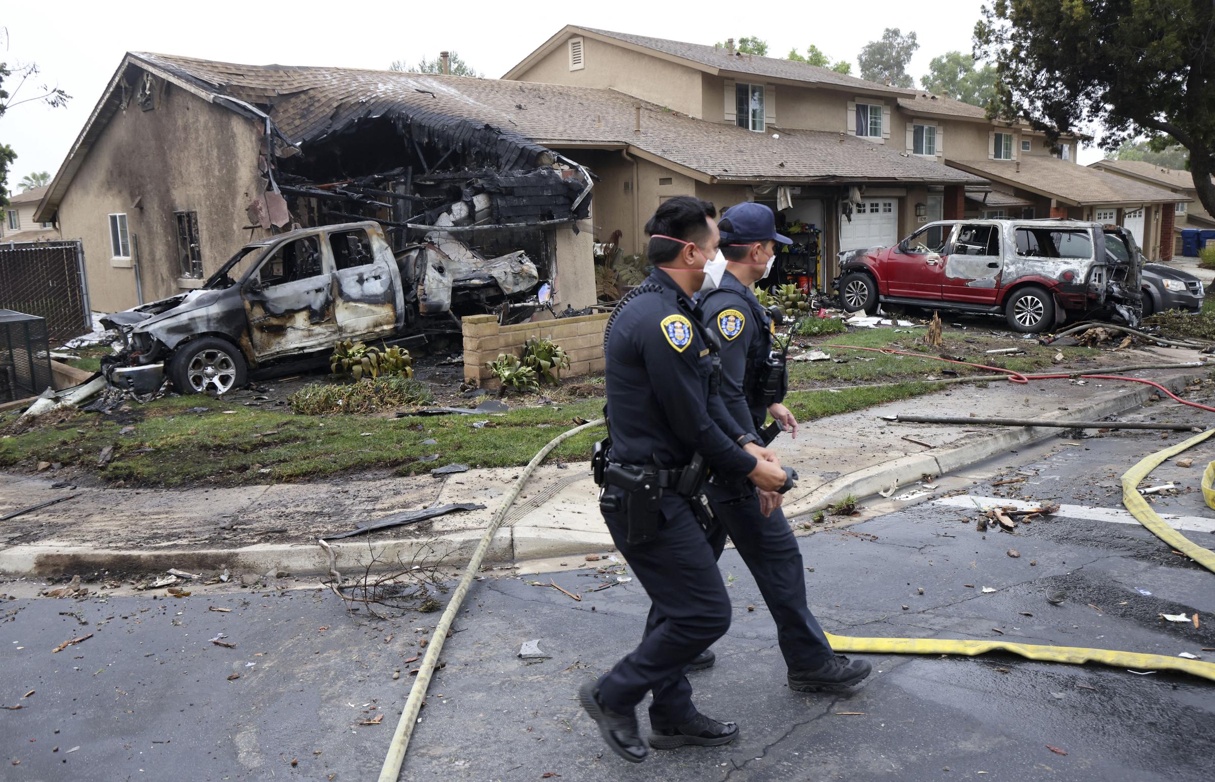 Police officers search the crash site where a Cessna 550 jet slammed into homes on a residential street in San Diego, California, on May 22, 2025 | Source: Getty Images