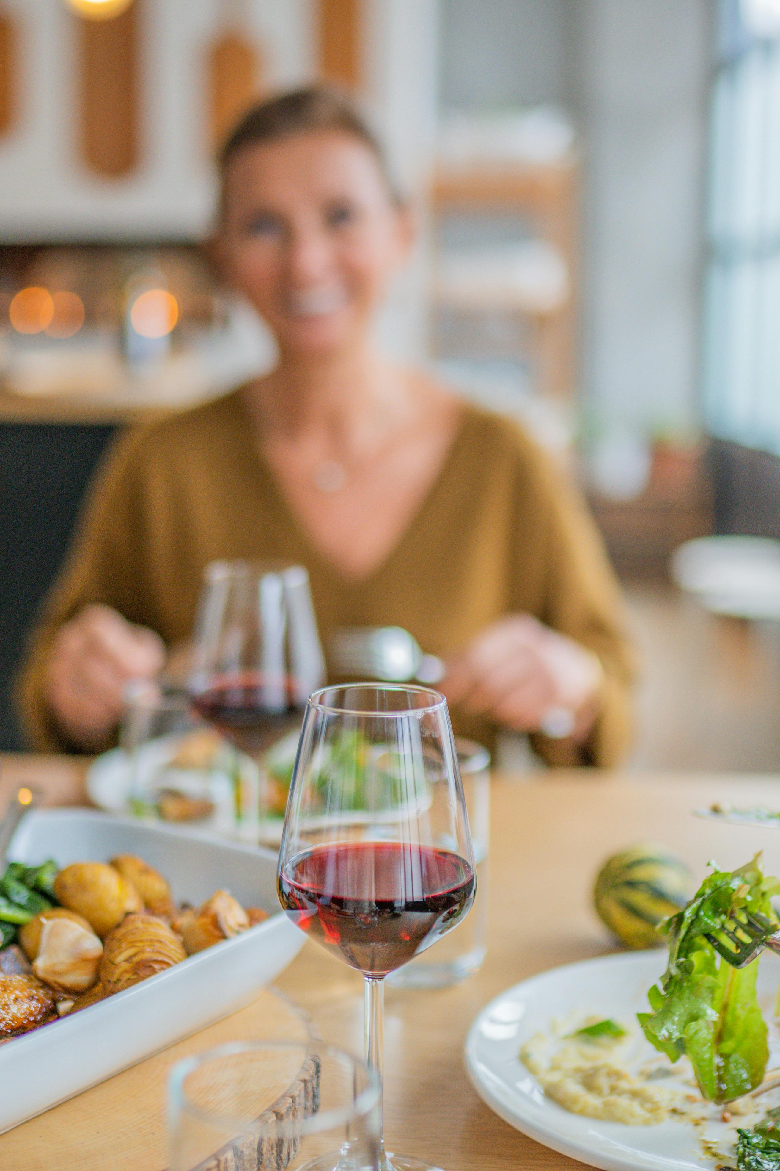 A blurry photo of a woman smiling while eating | Source: Pexels