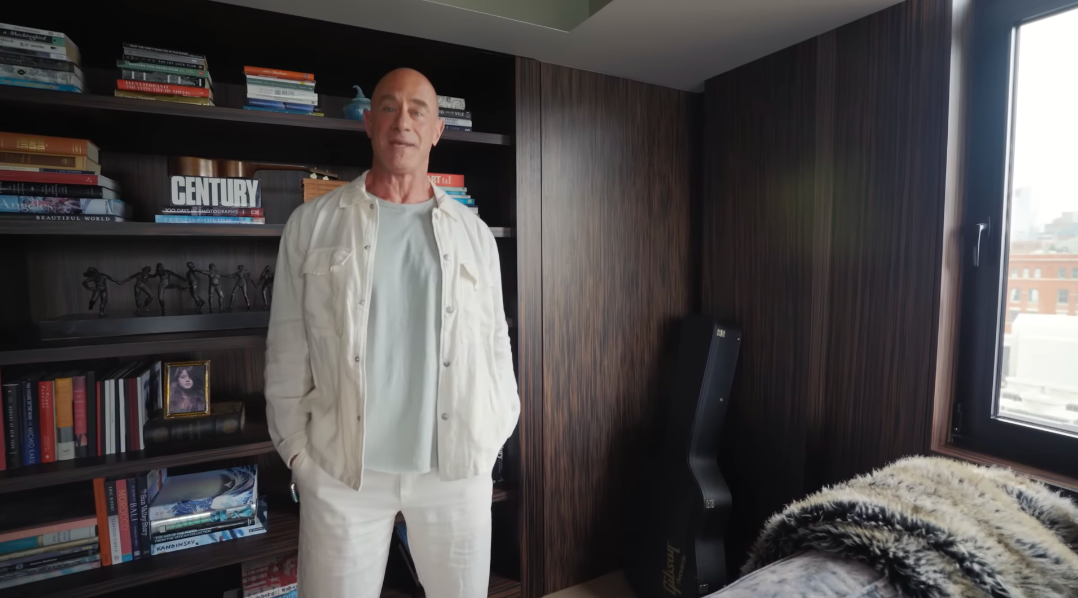 Christopher's media room feels collected over time rather than decorated in one sweep. Books, sculptures, photographs and a guitar case make the darker room particularly personal. | Source: YouTube/Architectural Digest