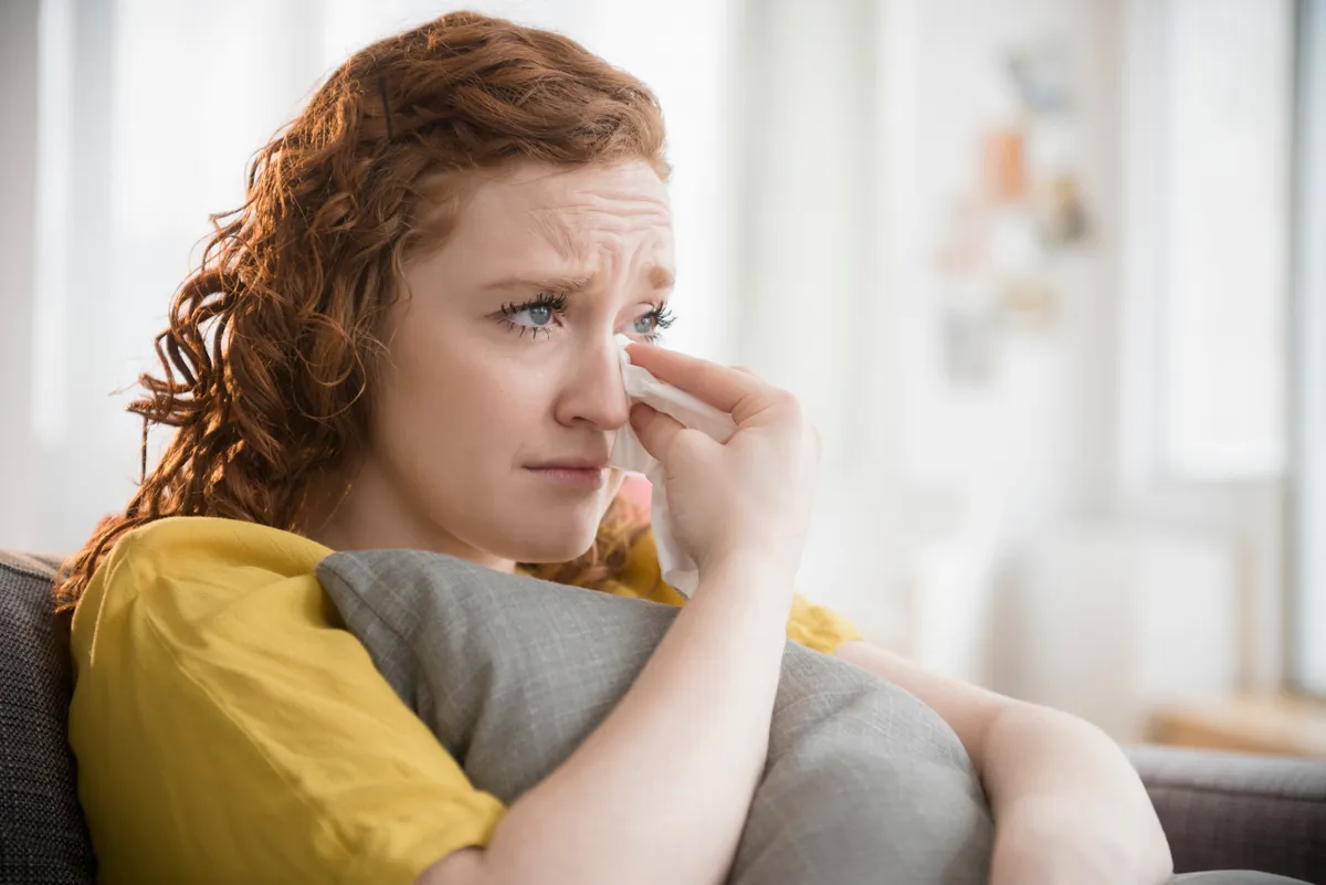 A woman in tears clutching a pillow | Source: Getty Images