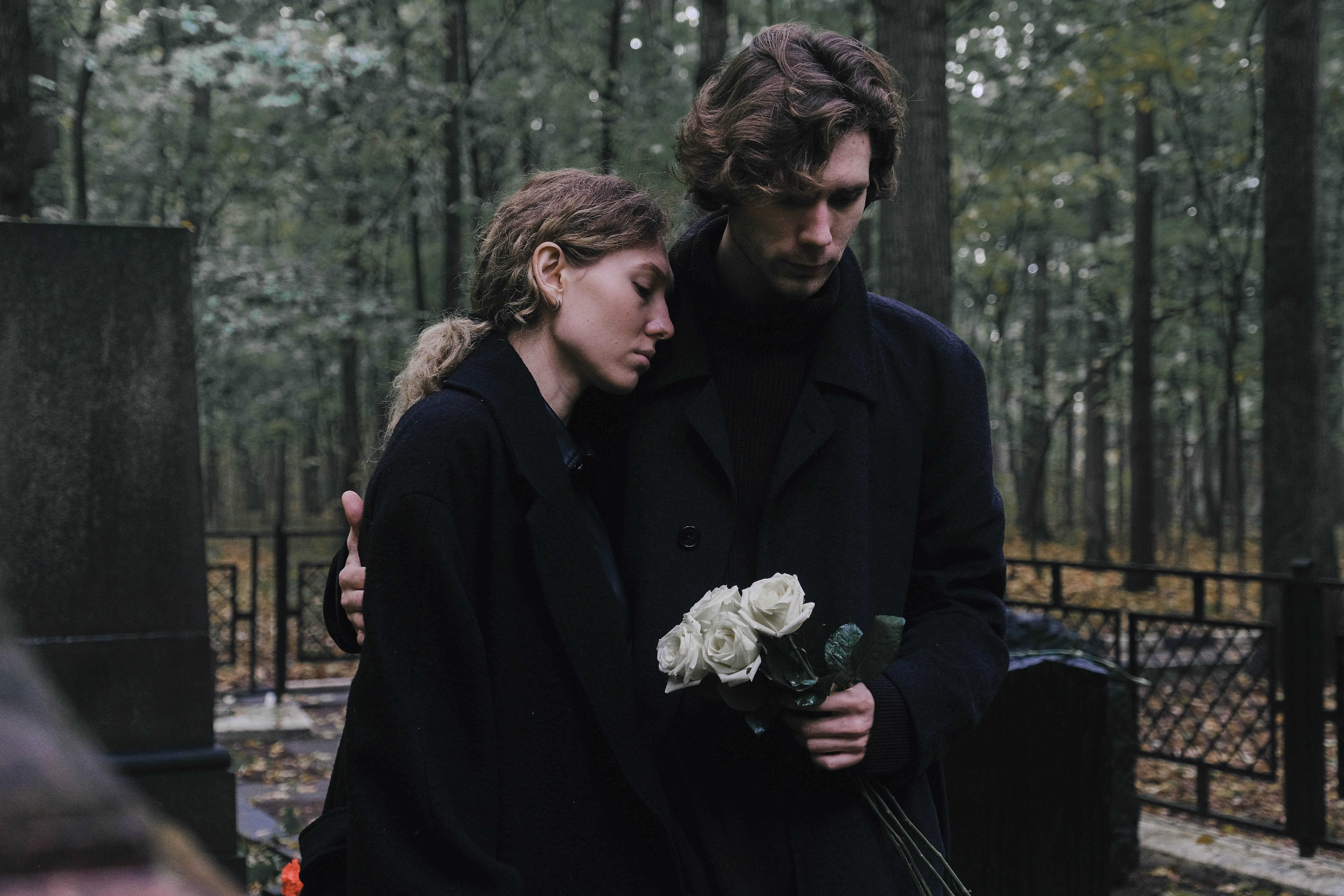 Young couple man and woman mourn at the cemetery for the loss | Source: Getty Images