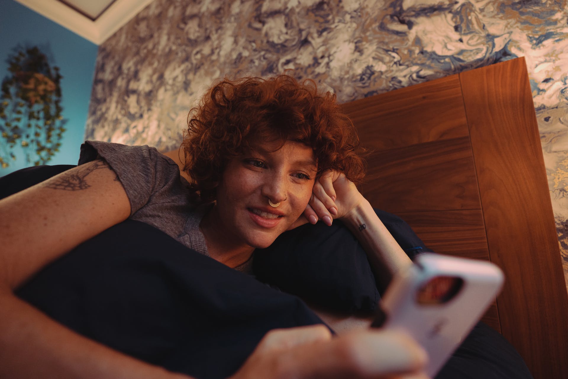 A woman using her phone on the bed | Source: Pexels