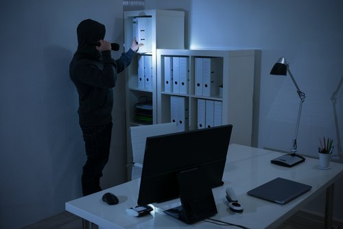 A robber seaching for valuables by flashlight. | Source: Shutterstock.