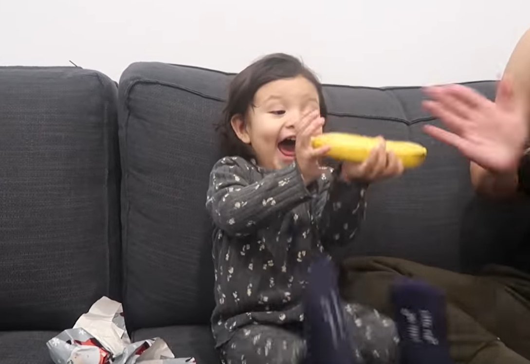 Petite fille est enthousiasmée par le cadeau de Noël banane | Photo: YouTube / LGNDFRVR