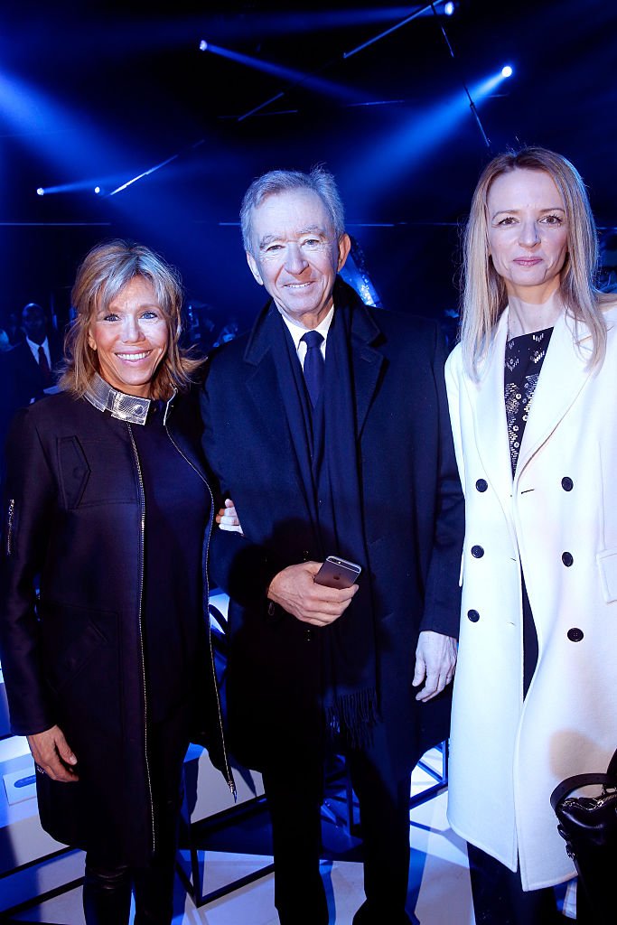 Brigitte Macron, Bernard Arnault et Delphine Arnault lors du défilé Louis Vuitton de la Fashion Week de Paris le 9 mars 2016. l Source : Getty Images