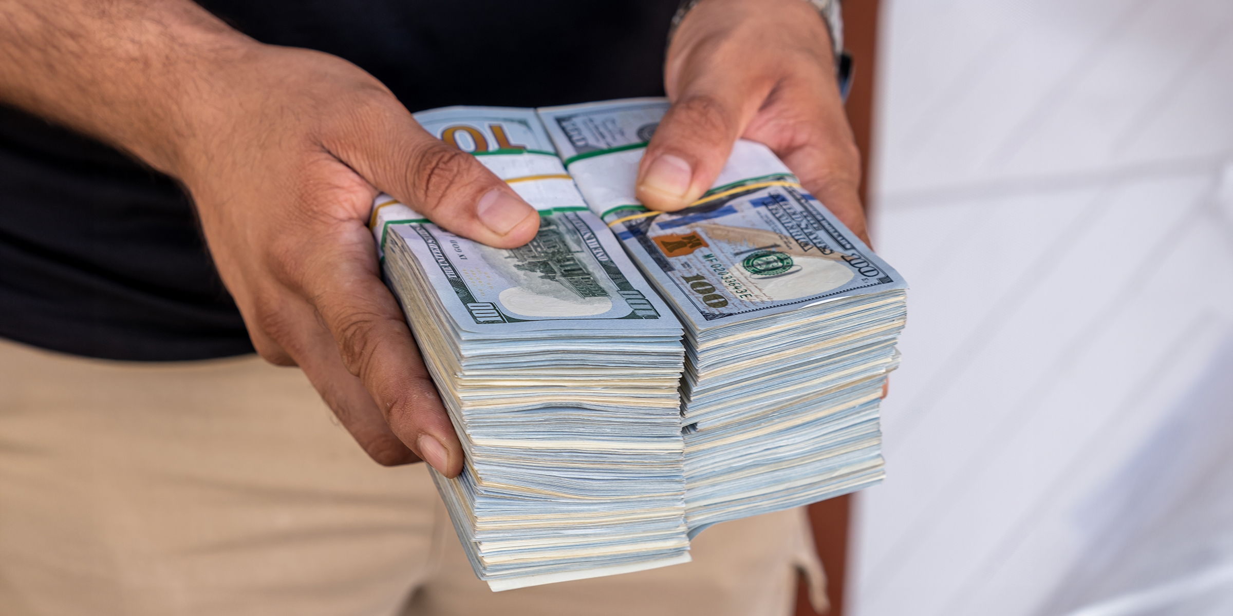 A man holding a stack of money | Source: Shutterstock