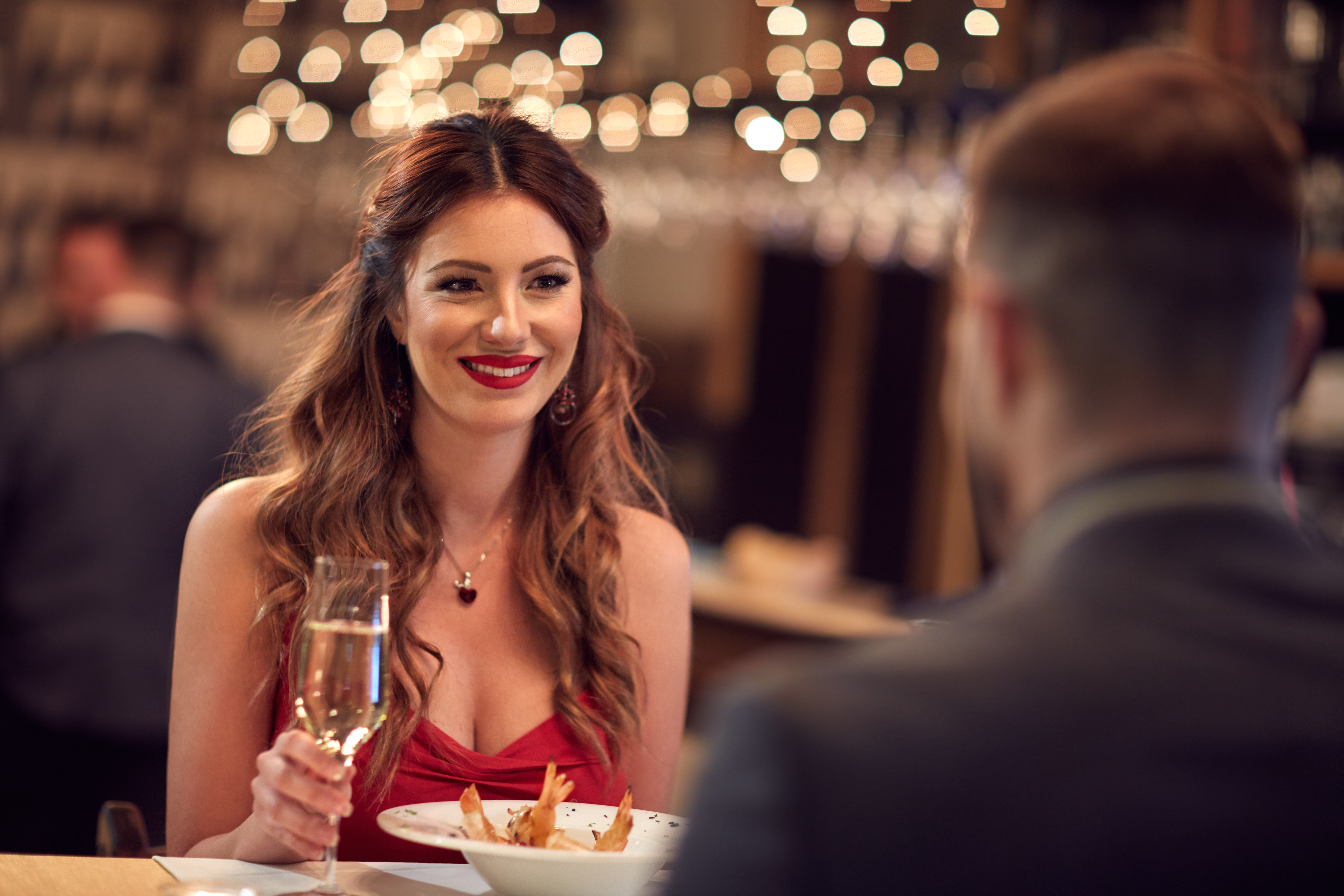 Woman in red dress dining out with her boyfriend | Source: Shutterstock