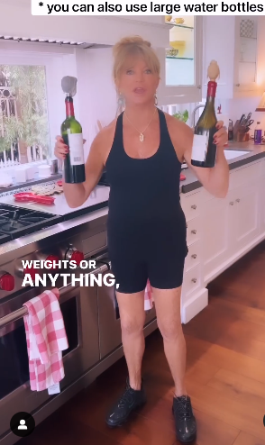Goldie Hawn lifting using wine bottles as barbells as works out. | Source: instagram.com/goldiehawn