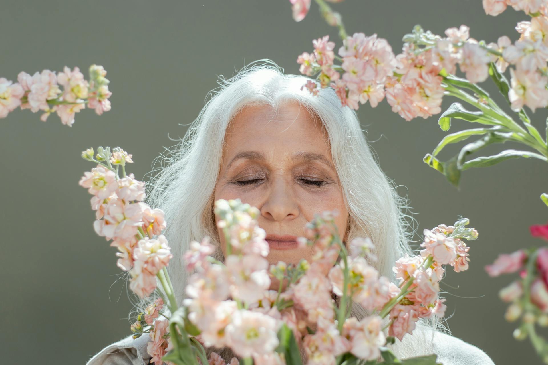 Mature woman smelling flowers | Source: Pexels