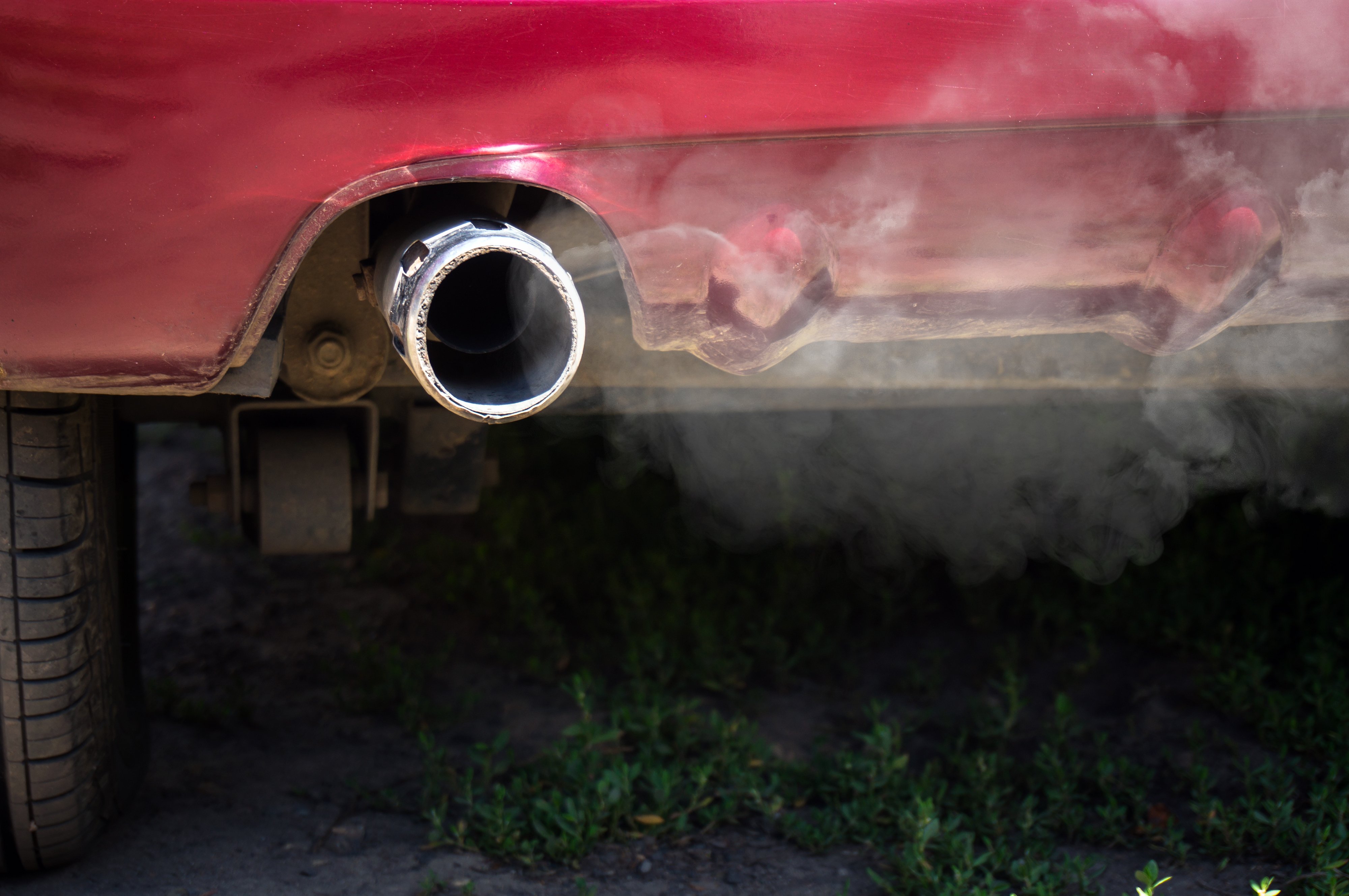 A parked car running with white smoke coming out of the exhaust pipe | Photo: Shutterstock