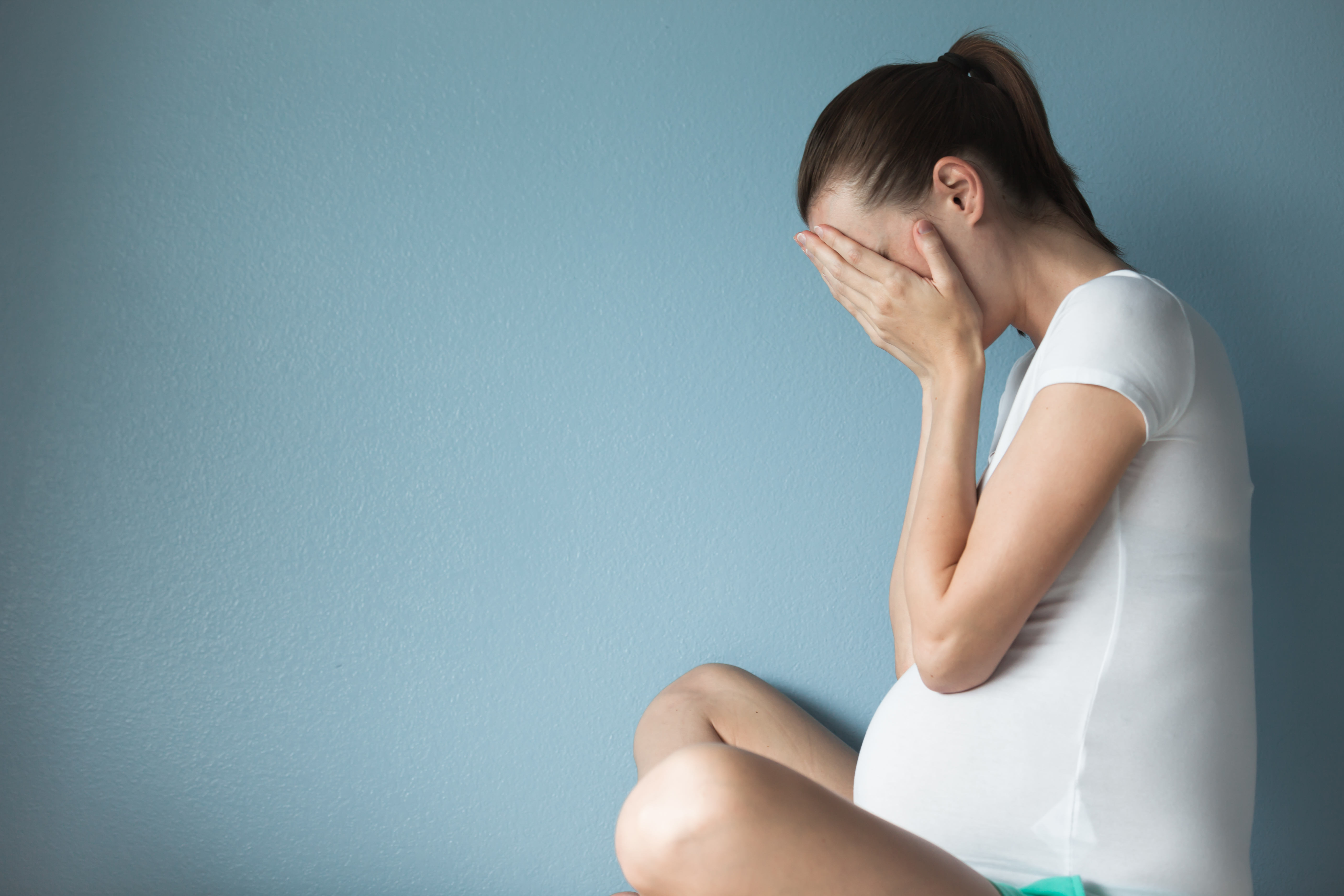 A pregnant woman with her head in her hands | Source: Shutterstock