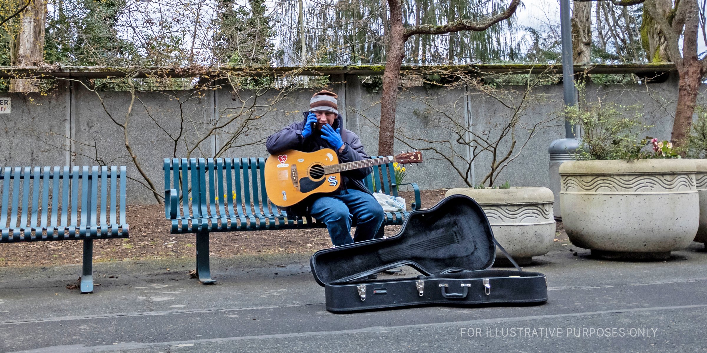 Man playing guitar outside. | Source: Shutterstock
