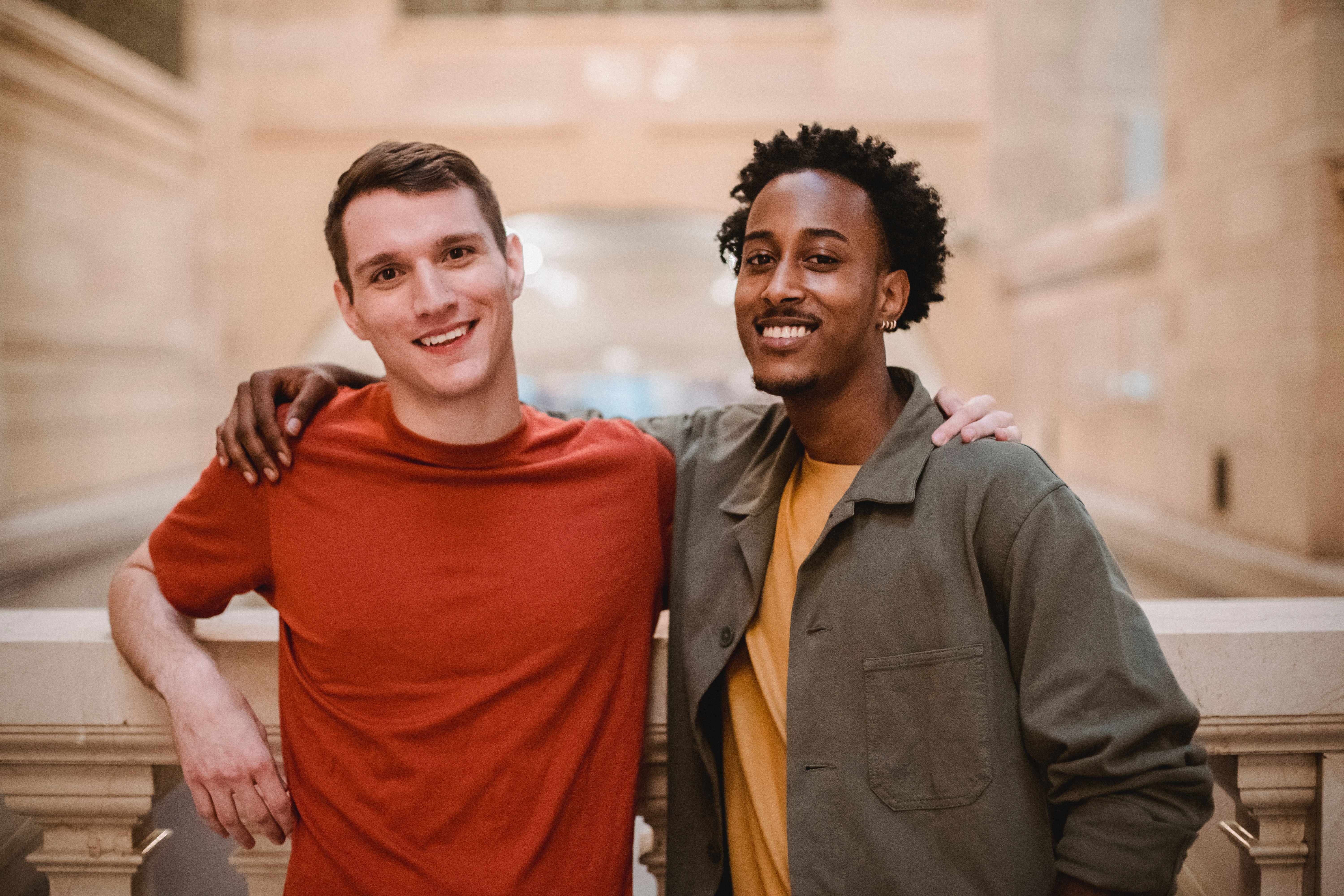 Two smiling male friends with their arms around each other | Photo: Pexels