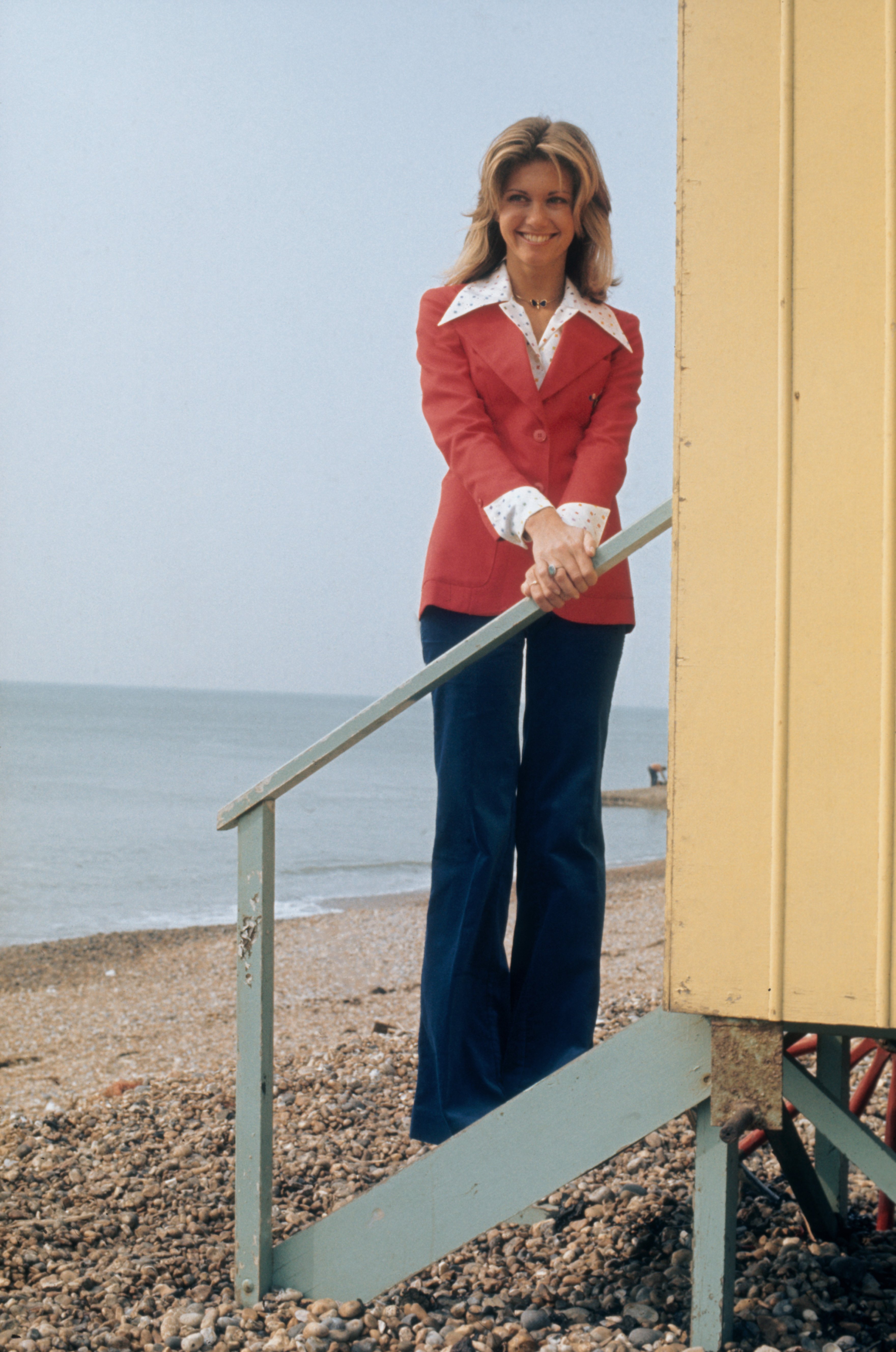 British-born actress Olivia Newton-John poses on the steps of a beach hut, circa 1975 | Source: Getty Images
