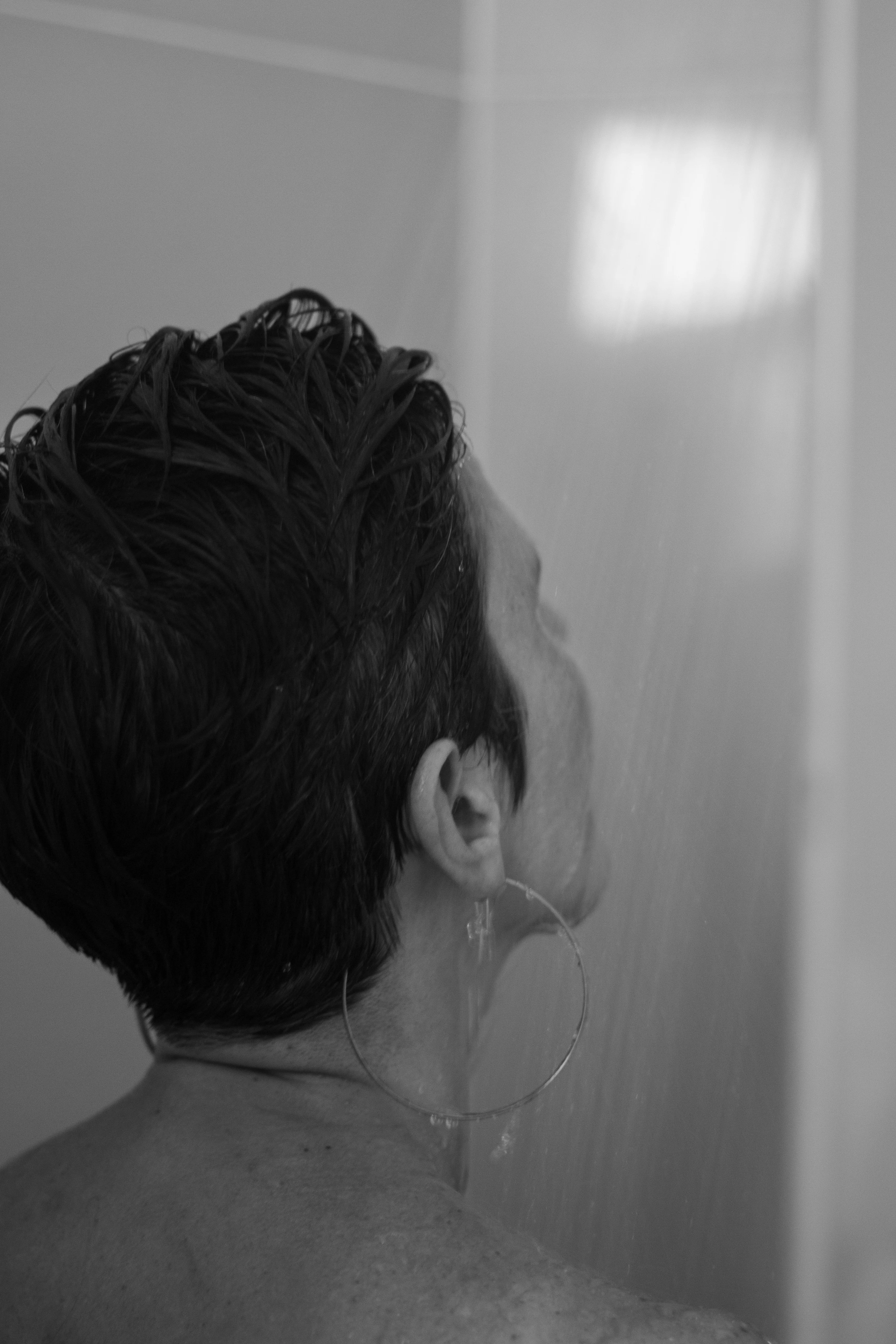 A person showers under running water. | Source: Pexels