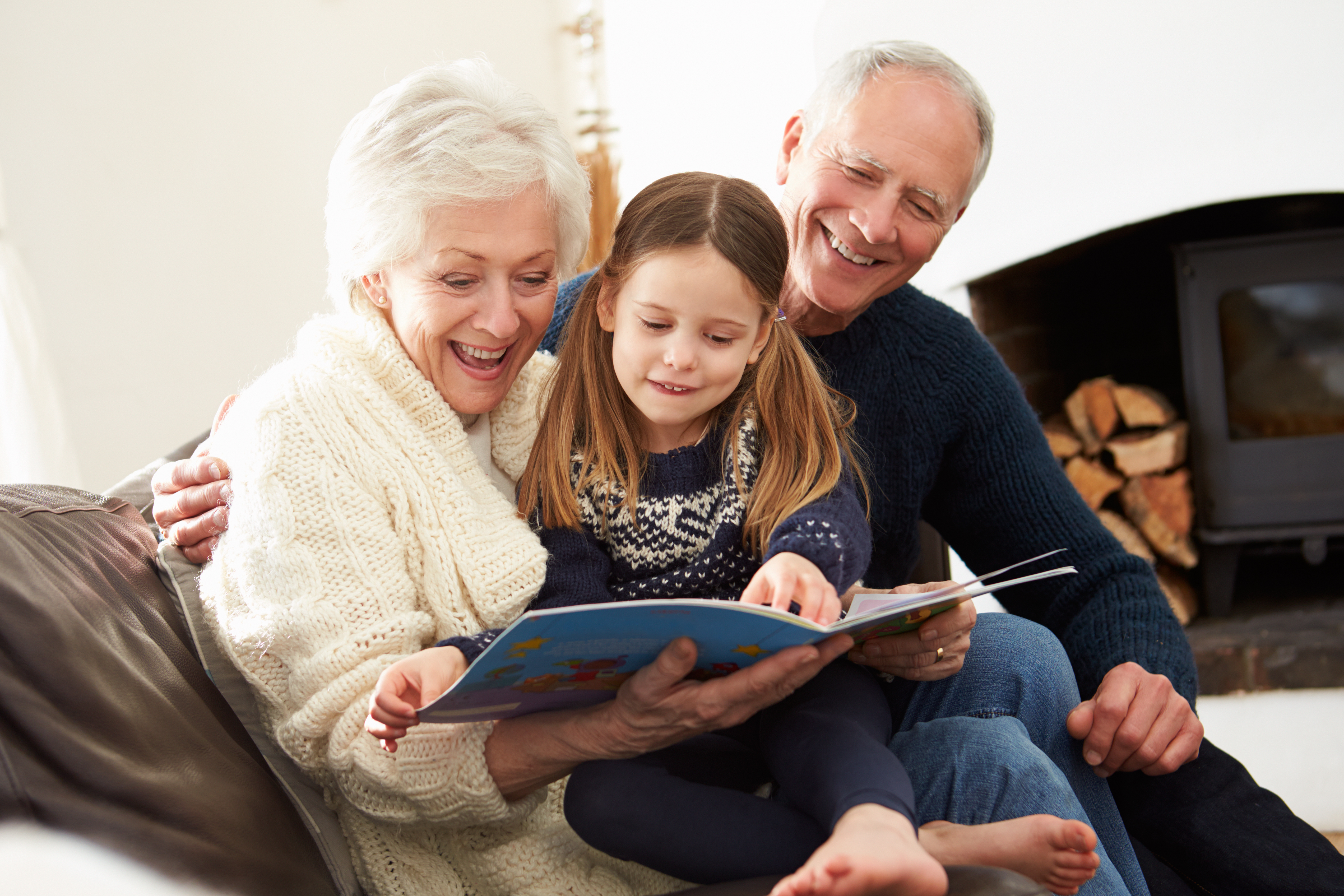 Grandparents reading a book to their granddaughter | Source: Shutterstock
