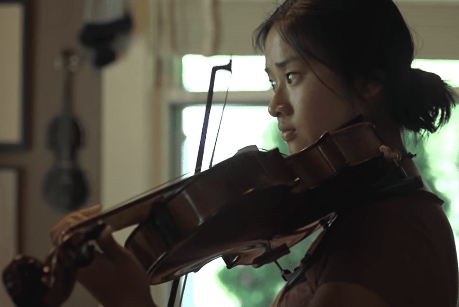 Kati Pohler playing a violin | Source: YouTube/BBC Stories