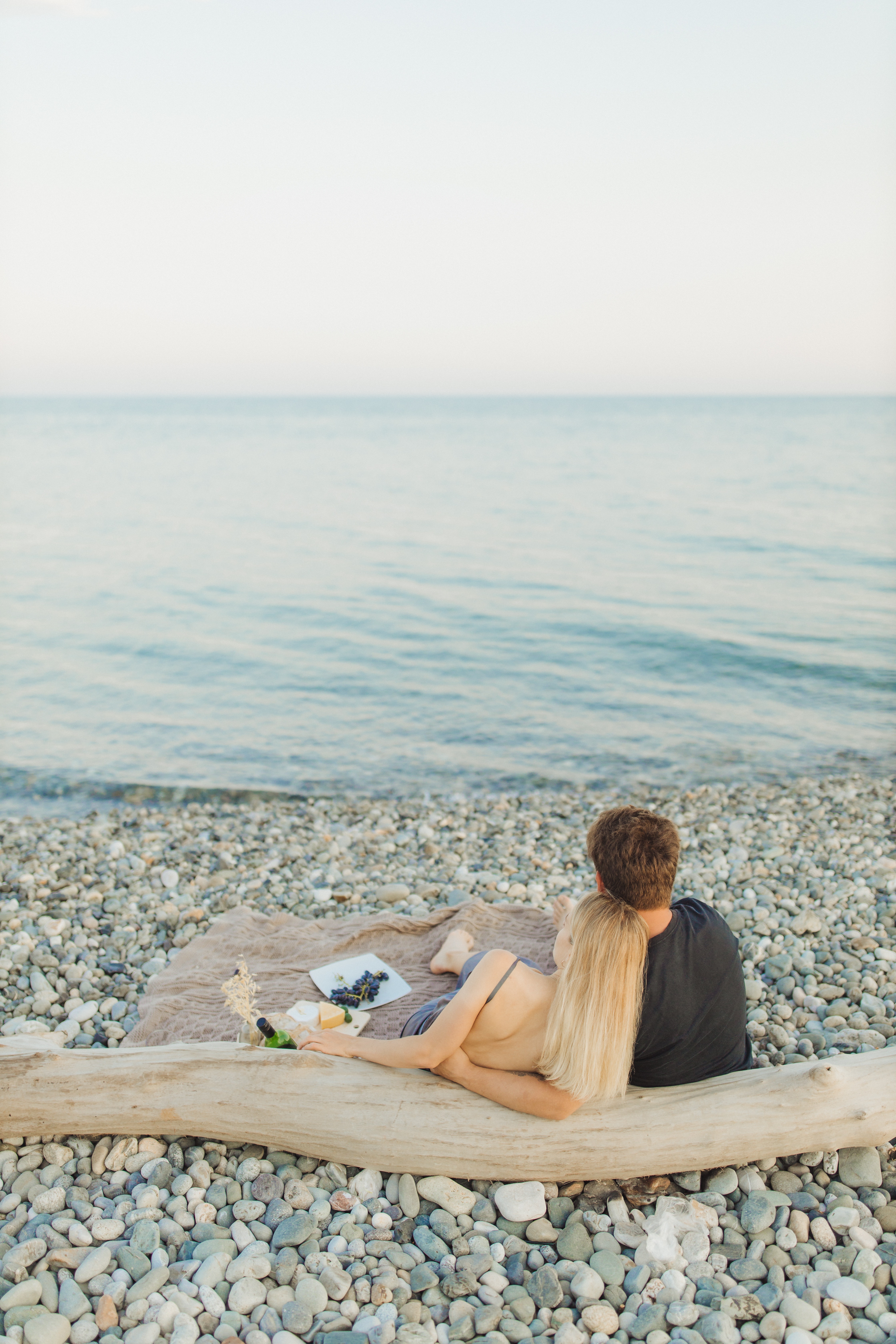 A man and a woman enjoying a peaceful date by the shoreline. | Source: Pexels