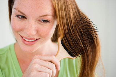 Image d'une femme qui se peigne les cheveux | Photo : Shutterstock