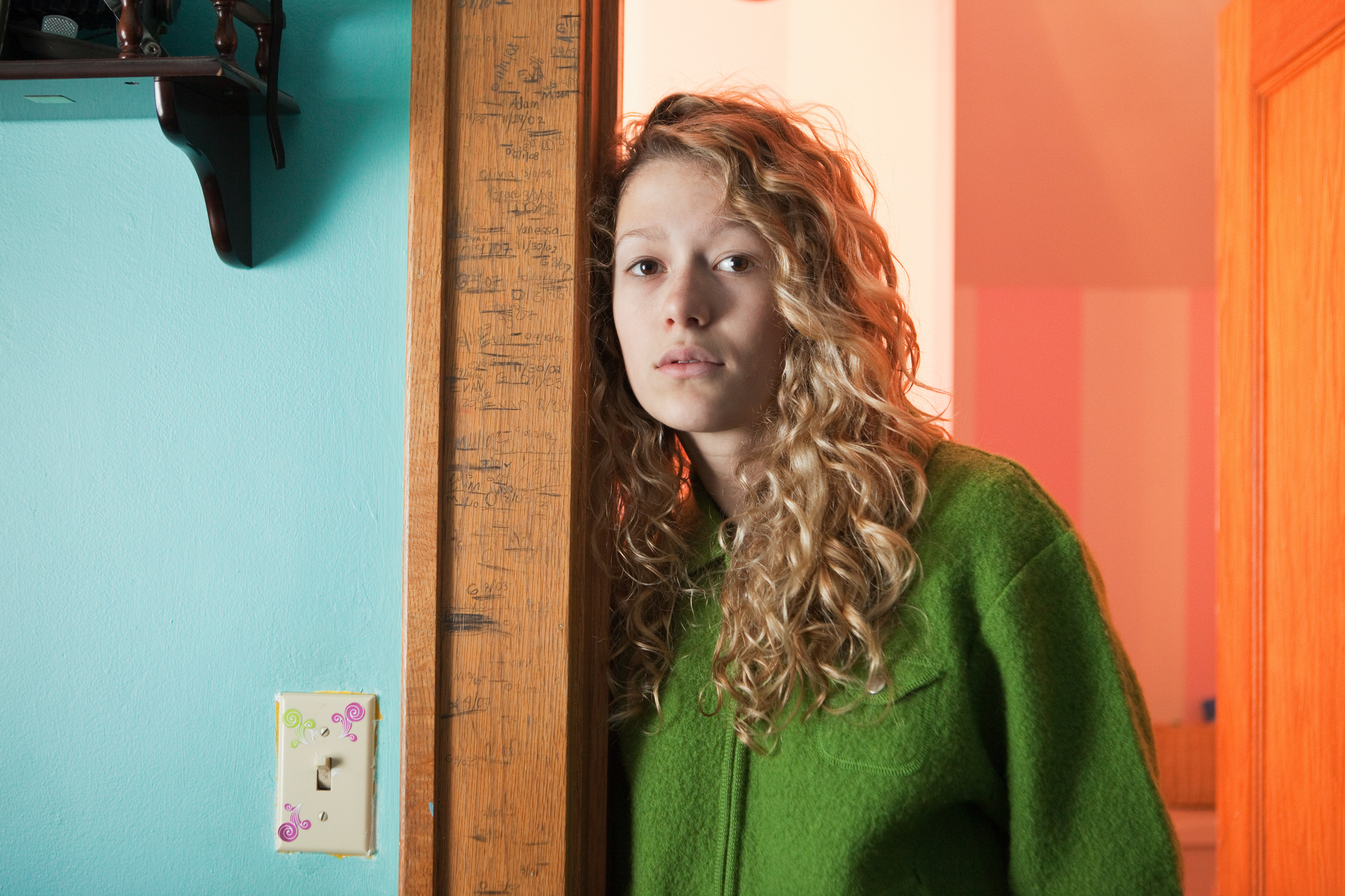 Teenage girl leaning in doorway, portrait | Source: Getty Images