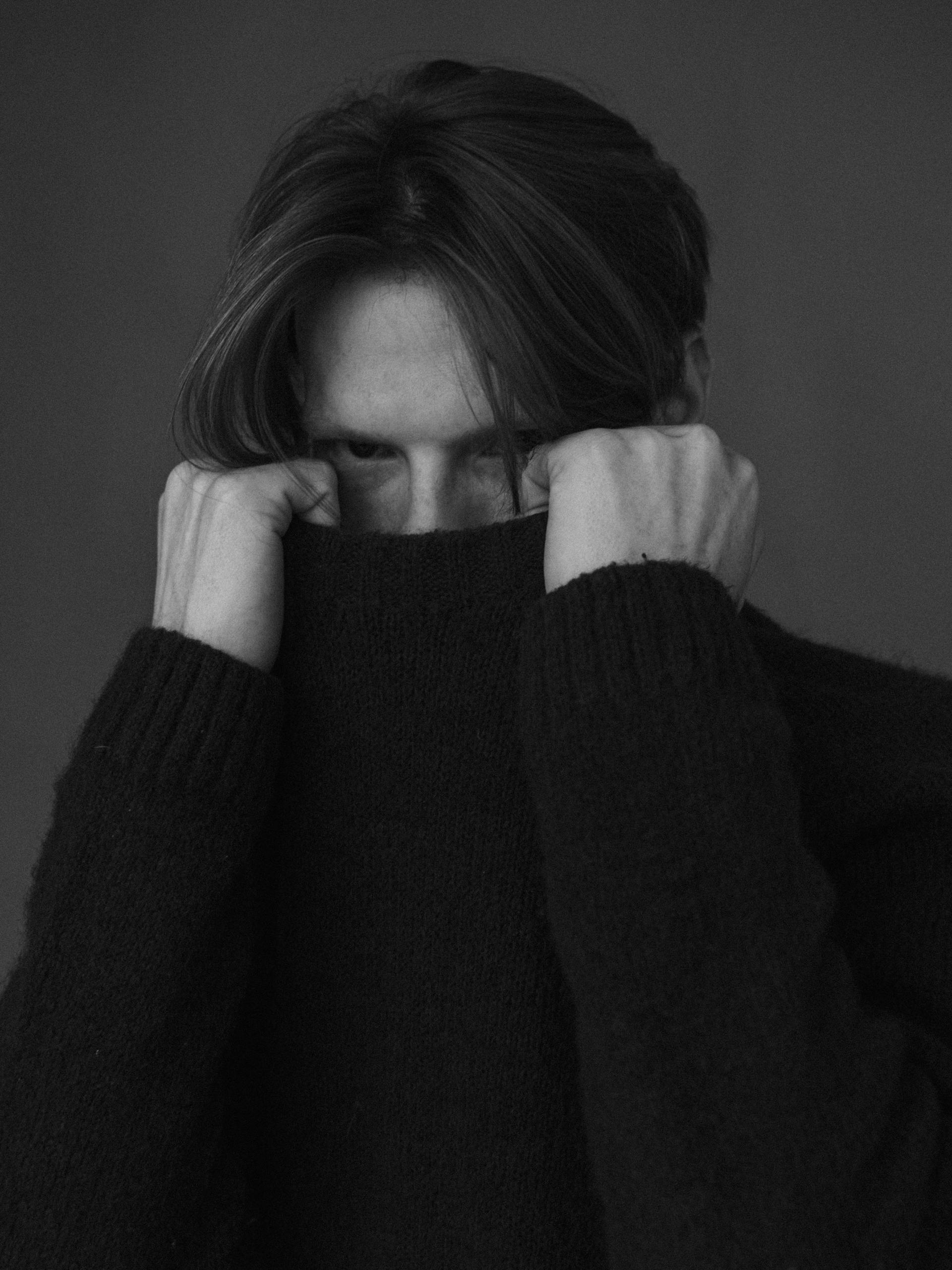 A man pulling up his sweater to cover his face | Source: Pexels