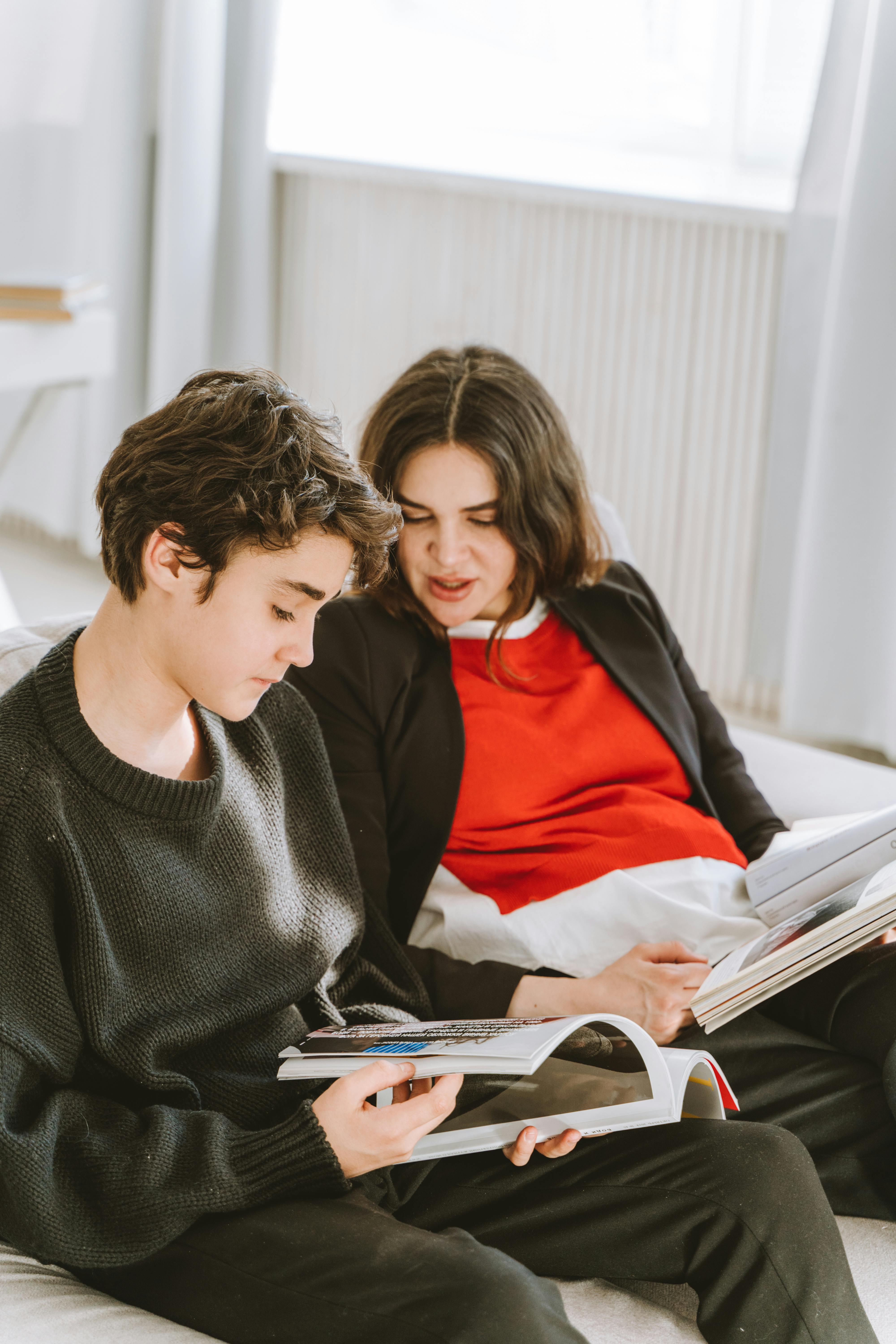 A woman talking to her son while looking at the magazine | Source: Pexels