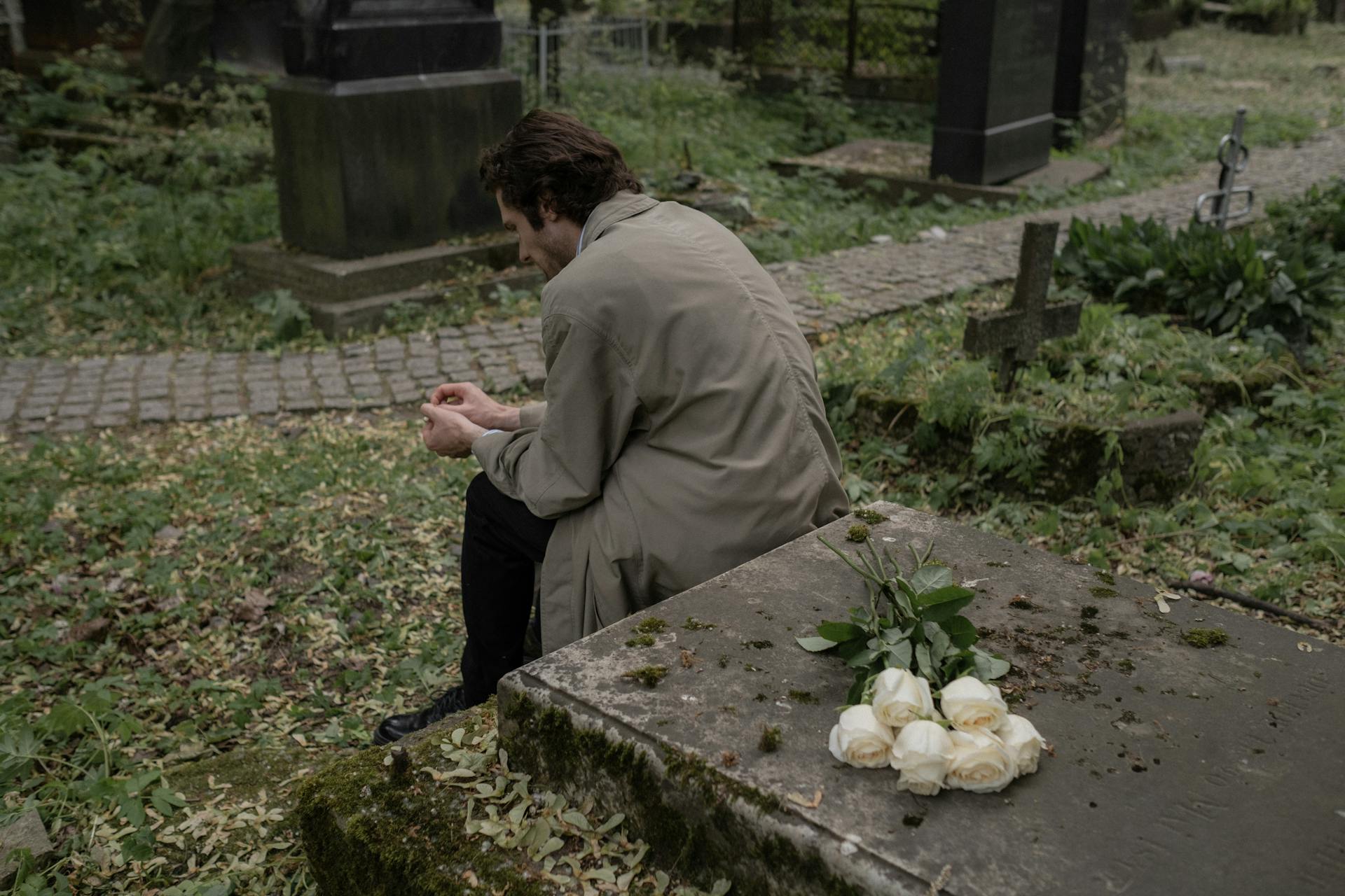 A man sitting by a grave | Source: Pexels