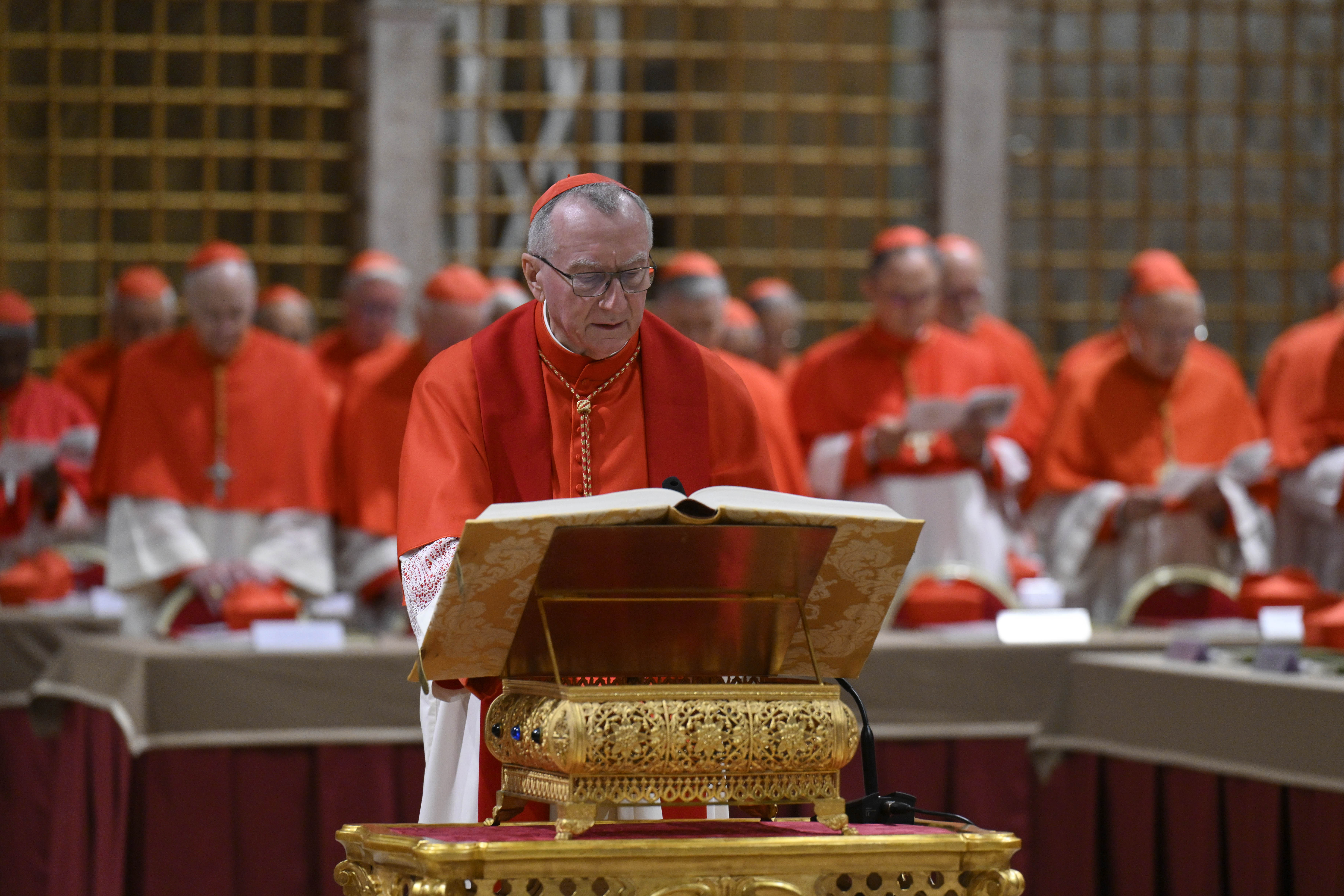 A cardinal reads from the Gospel as others stand in prayer during the papal conclave at the Vatican on May 7, 2025 | Source: Getty Images