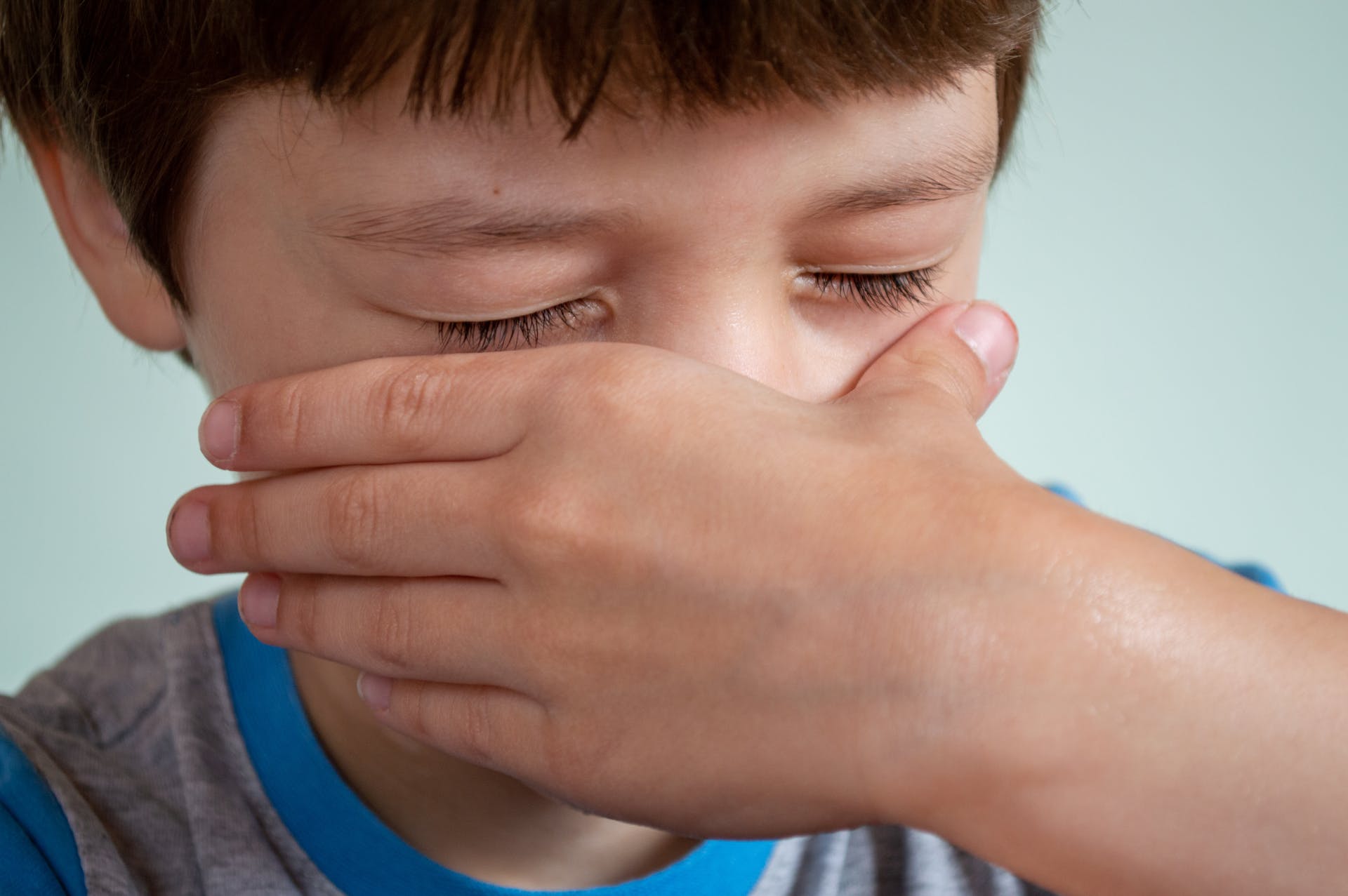 A child covering his nose with his hand | Source: Pexels