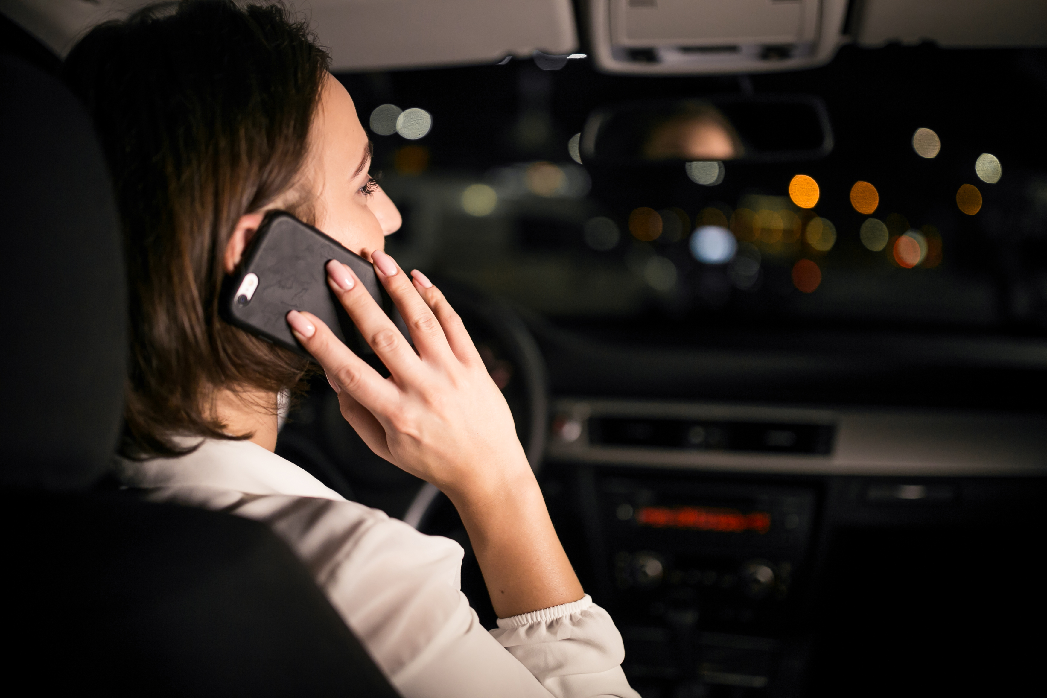 A woman sitting in her car and talking on the phone | Source: Freepik