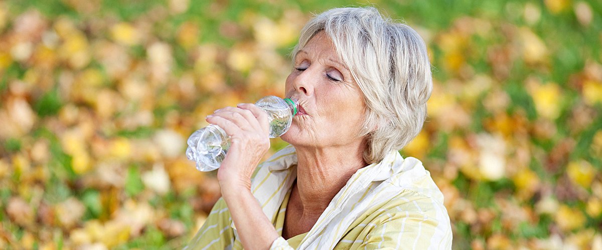Une femme mûre buvant de l'eau. | Photo : Shutterstock