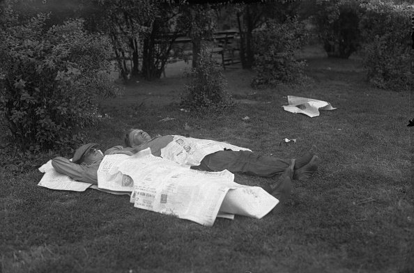 Two men sleeping in an open field.| Photo: Getty Images.