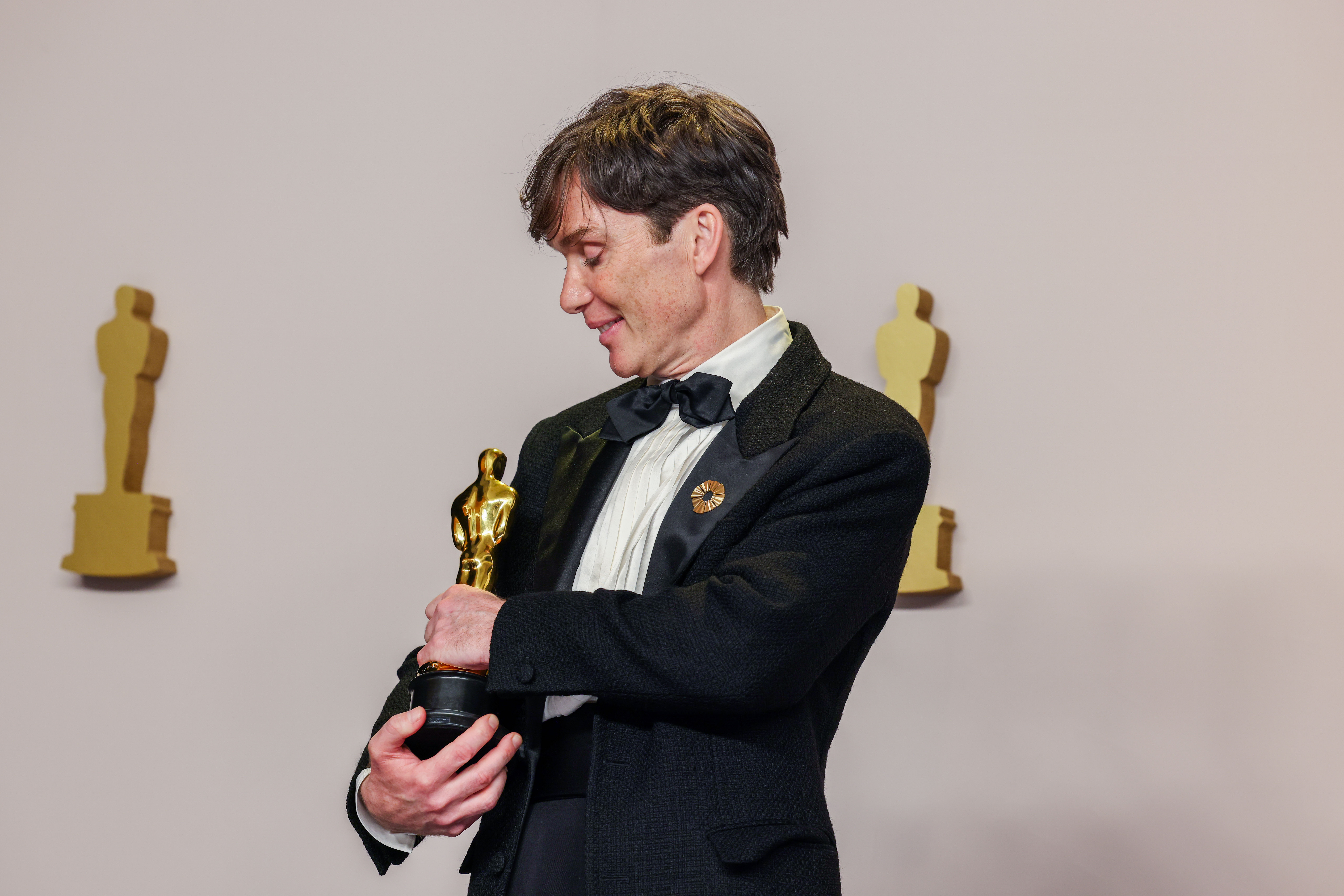 Irish actor Cillian Murphy looks at his Oscar while posing for photos in the press room at the 96th Annual Academy Awards in Hollywood, California on March 10, 2024. | Source: Getty Images