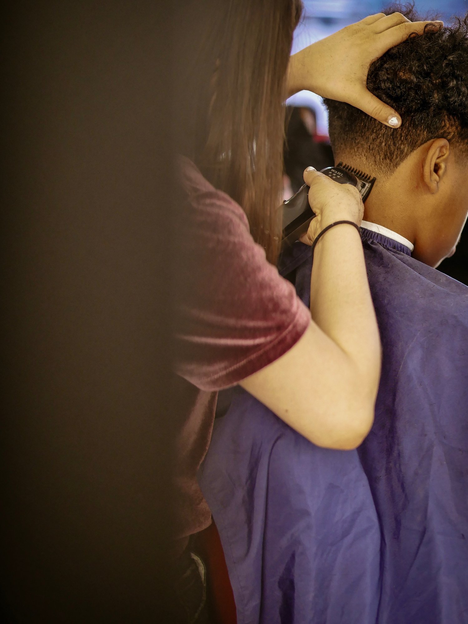 Woman shaving head of a boy at the  barber shop | Photo: Getty Images