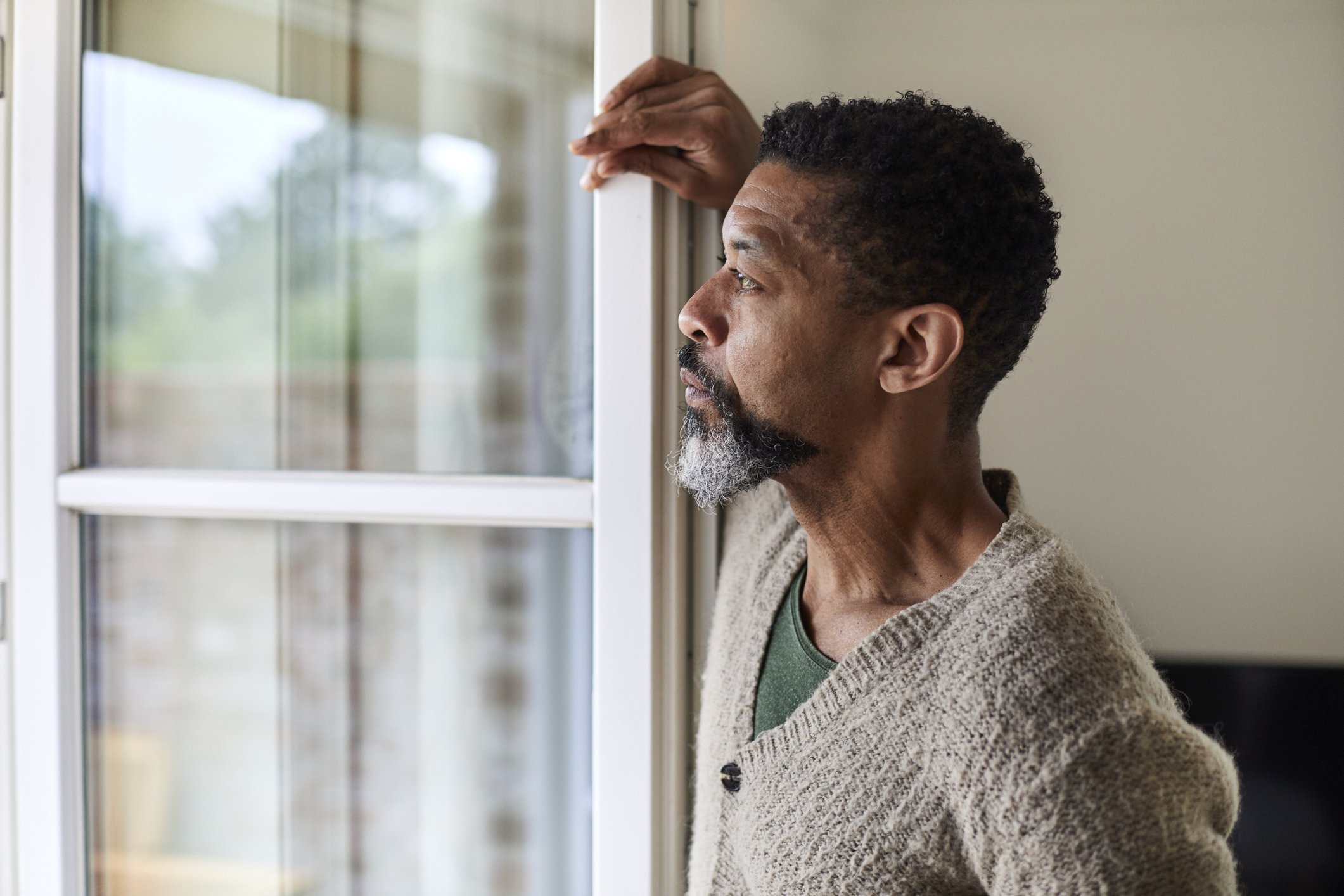 A worried man looks out the window in thoughts. | Photo: Getty Images