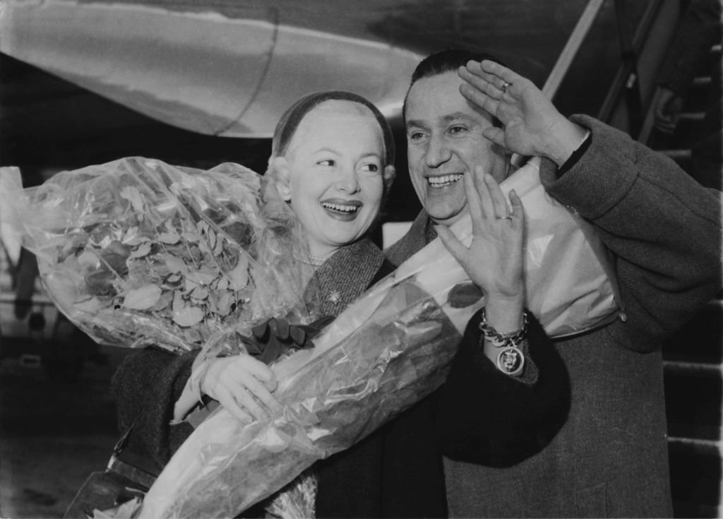 Olivia de Havilland et le journaliste français Pierre Galante (1909 - 1998) arrivent à l'aéroport d'Orly, Paris, le 27 décembre 1954. | Photo : Getty Images