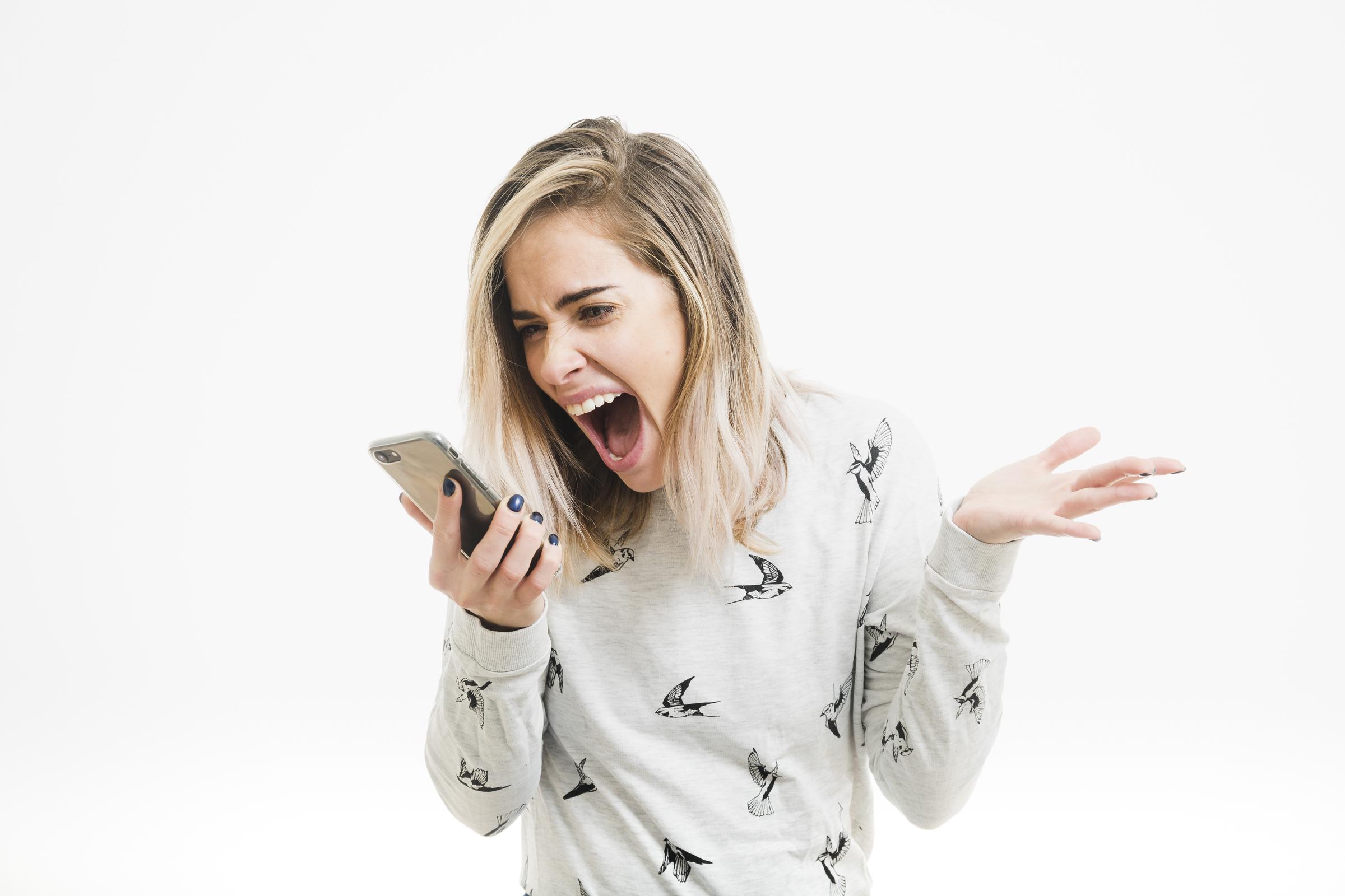 A woman screaming at her phone | Source: Freepik