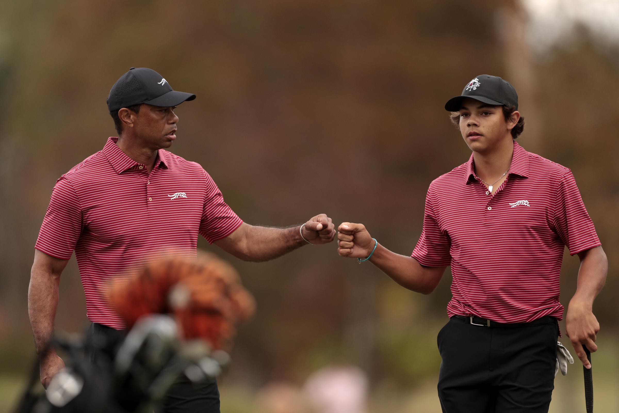 On the 16th green at the PNC Championship, Tiger Woods and Charlie Woods share a fist bump after a clutch moment during Round 2 in Orlando, Florida — pure focus and teamwork.