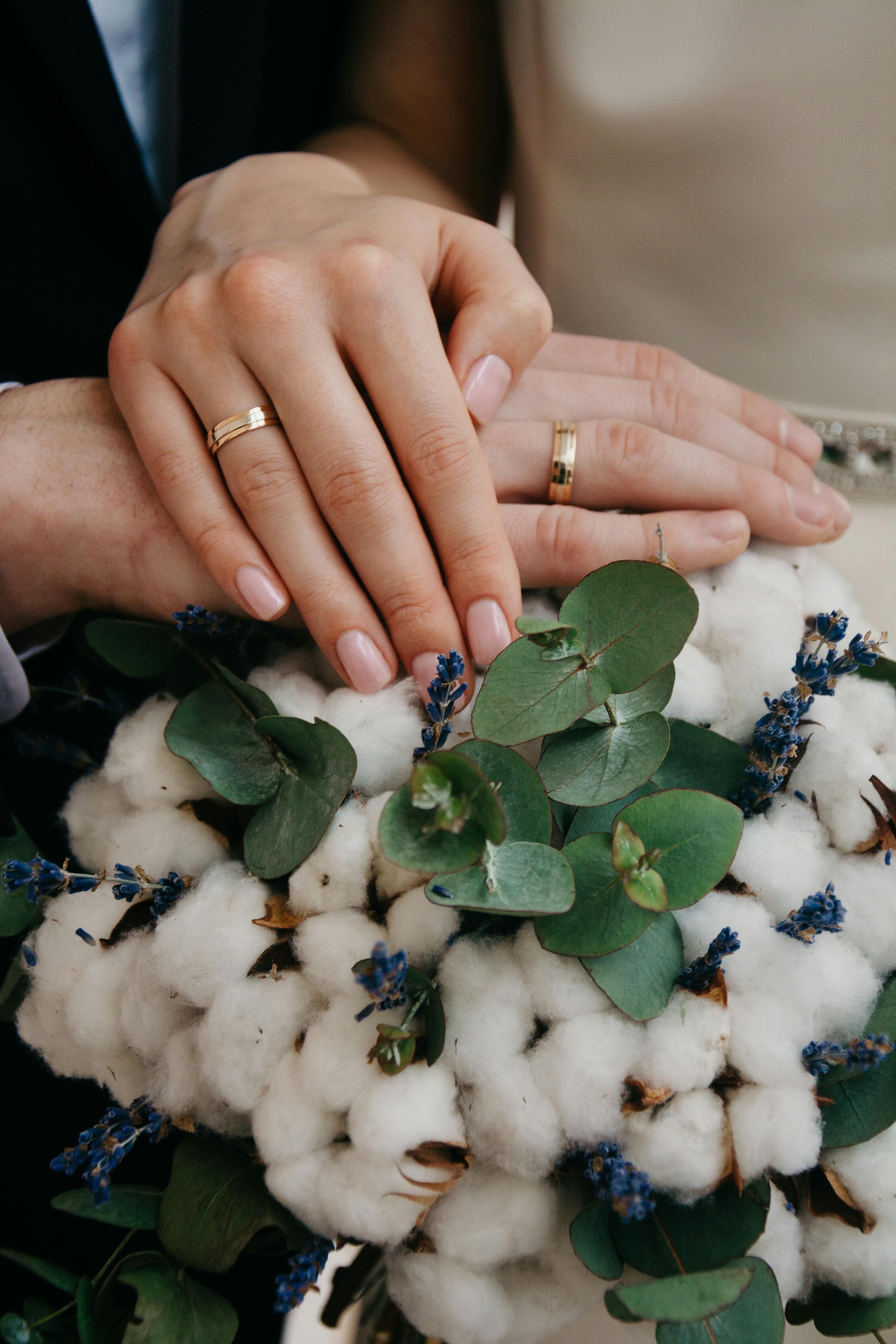 For illustration purposes only. A couple showing off their wedding bouquet and rings | Source: Pexels