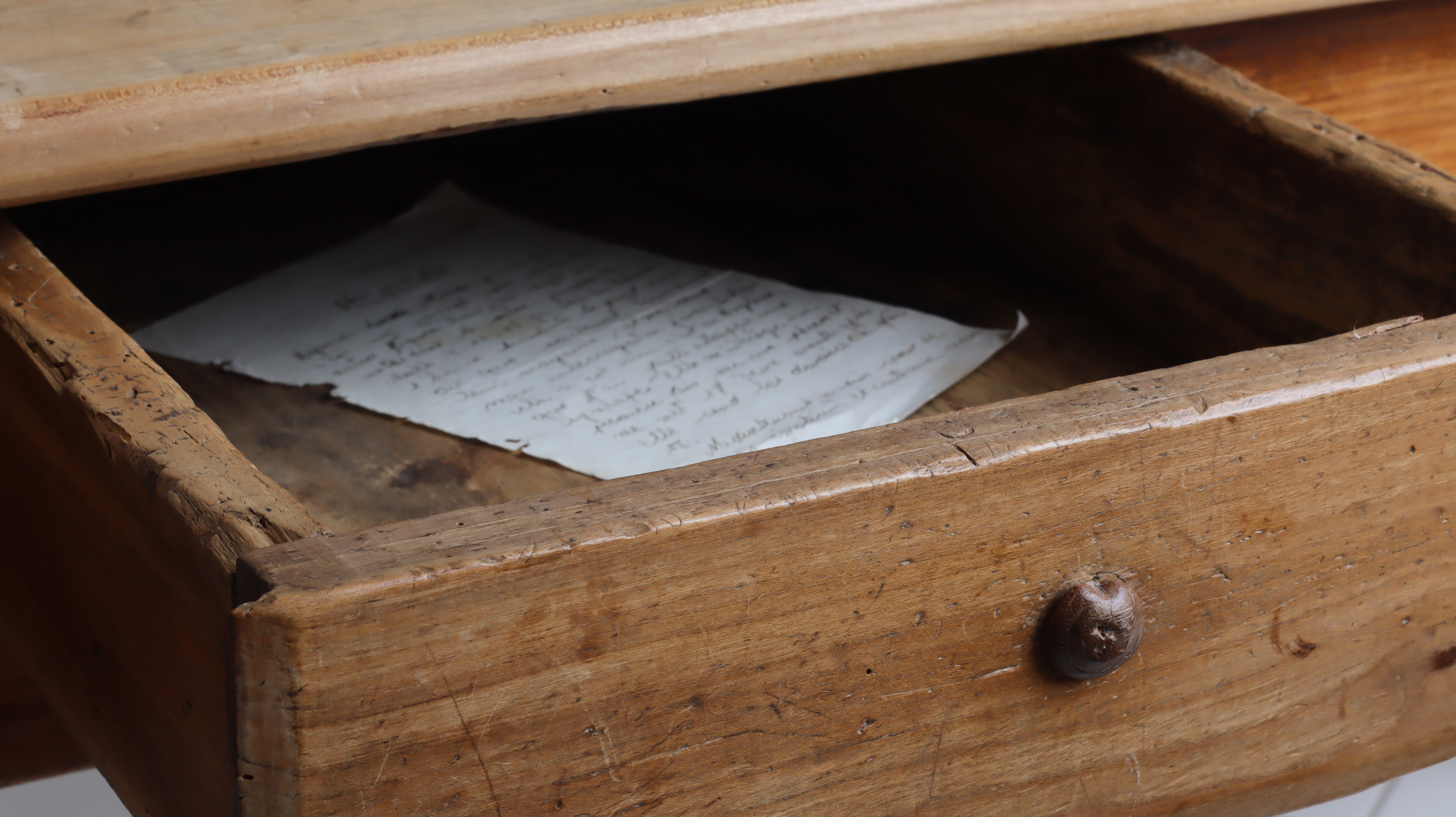Half-open drawer of old vintage wooden table with an old handwritten letter inside | Source: Shutterstock