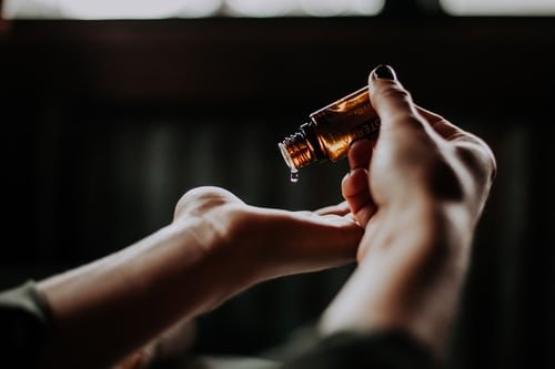 Quelqu'un versant de l'huile sur la main. | Photo : Unsplash