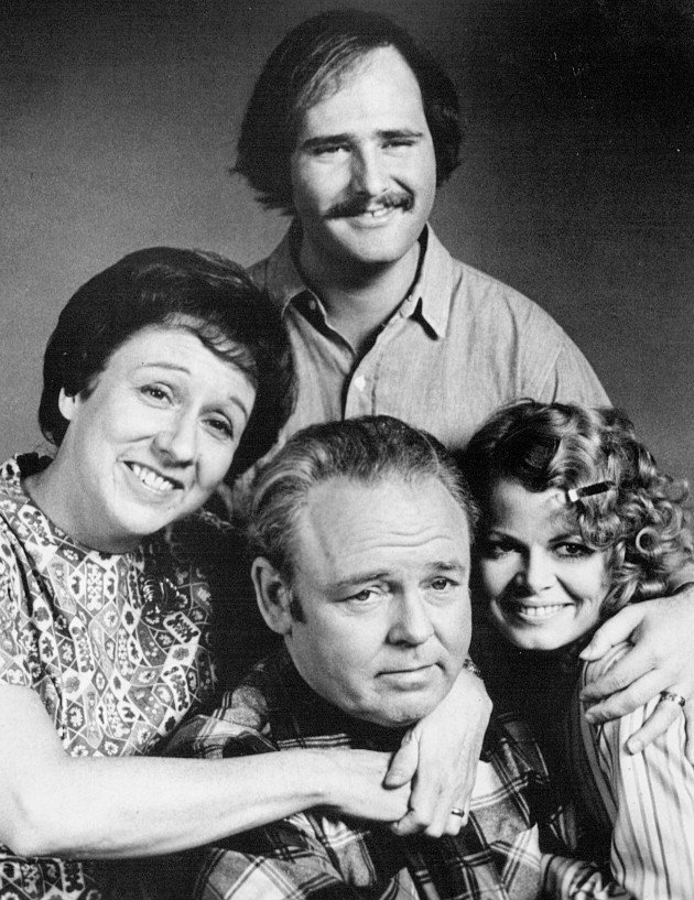 Cast photo from  "All In the Family." Back: Rob Reiner (Mike Stivic). Front, from left: Jean Stapleton (Edith Bunker), Carroll O'Connor (Archie Bunker), Sally Struthers (Gloria Bunker Stivic). | Source: Wikimedia Commons.