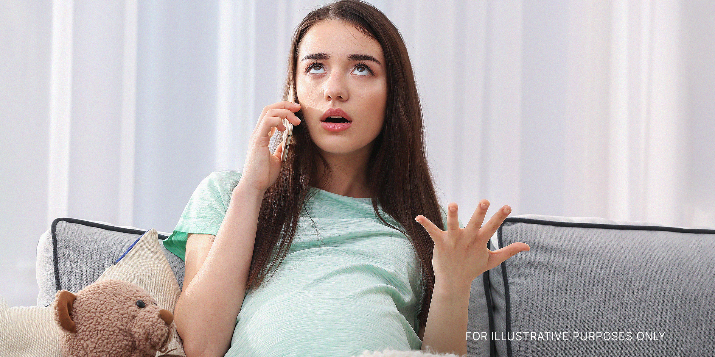 A pregnant woman looking annoyed while on the phone | Source: Shutterstock